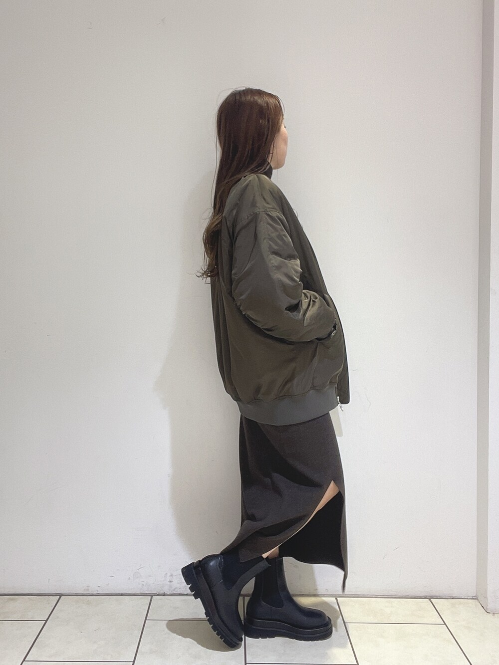 ブラウン系のニット/セーター、ブラウン系のスカート、ブラック系のブーツを着用したレディースの冬コーディネートの5枚目の写真