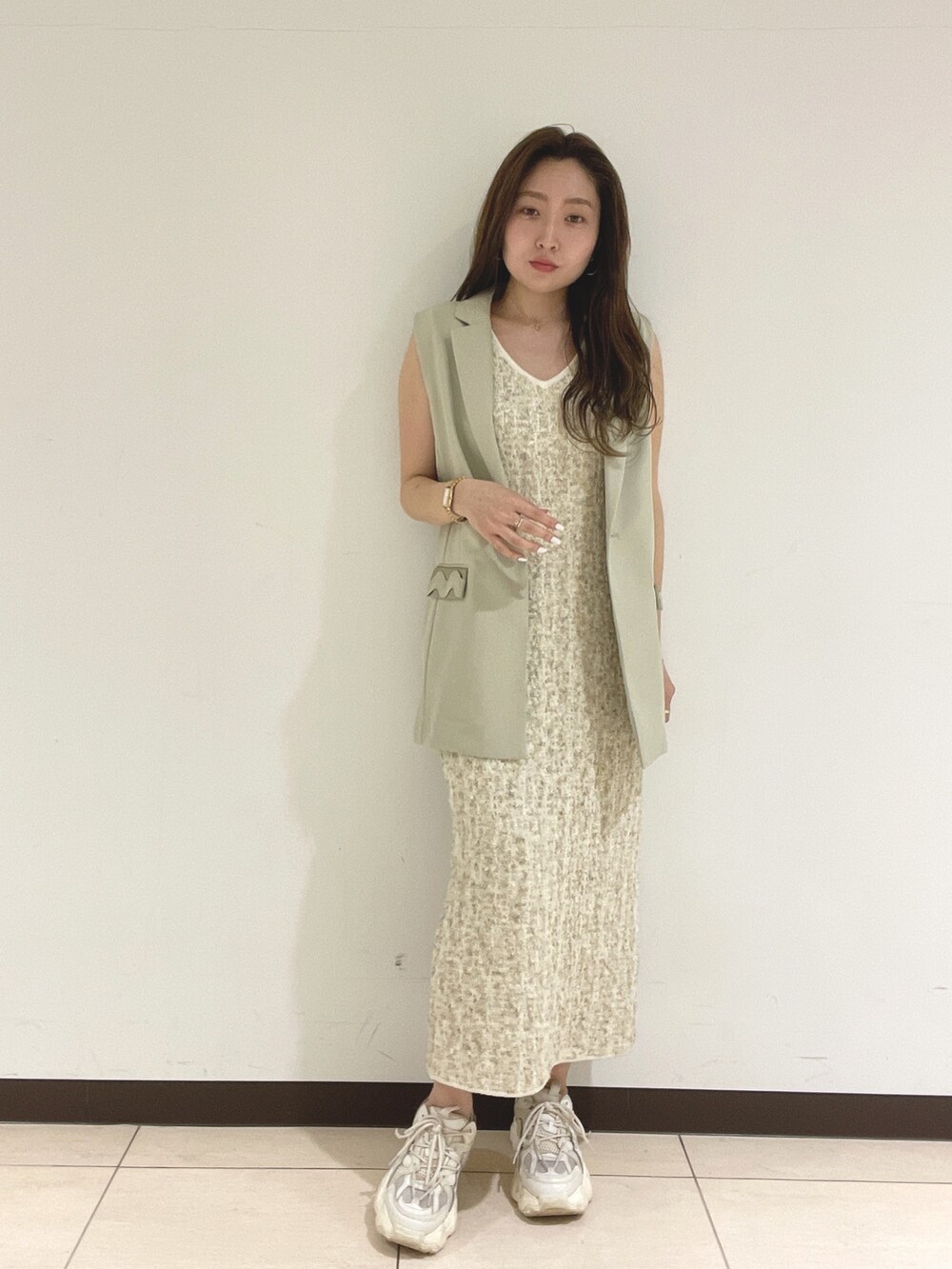 ホワイト系のワンピース、ベージュ系のベストを着用したレディースの春コーディネートの4枚目の写真