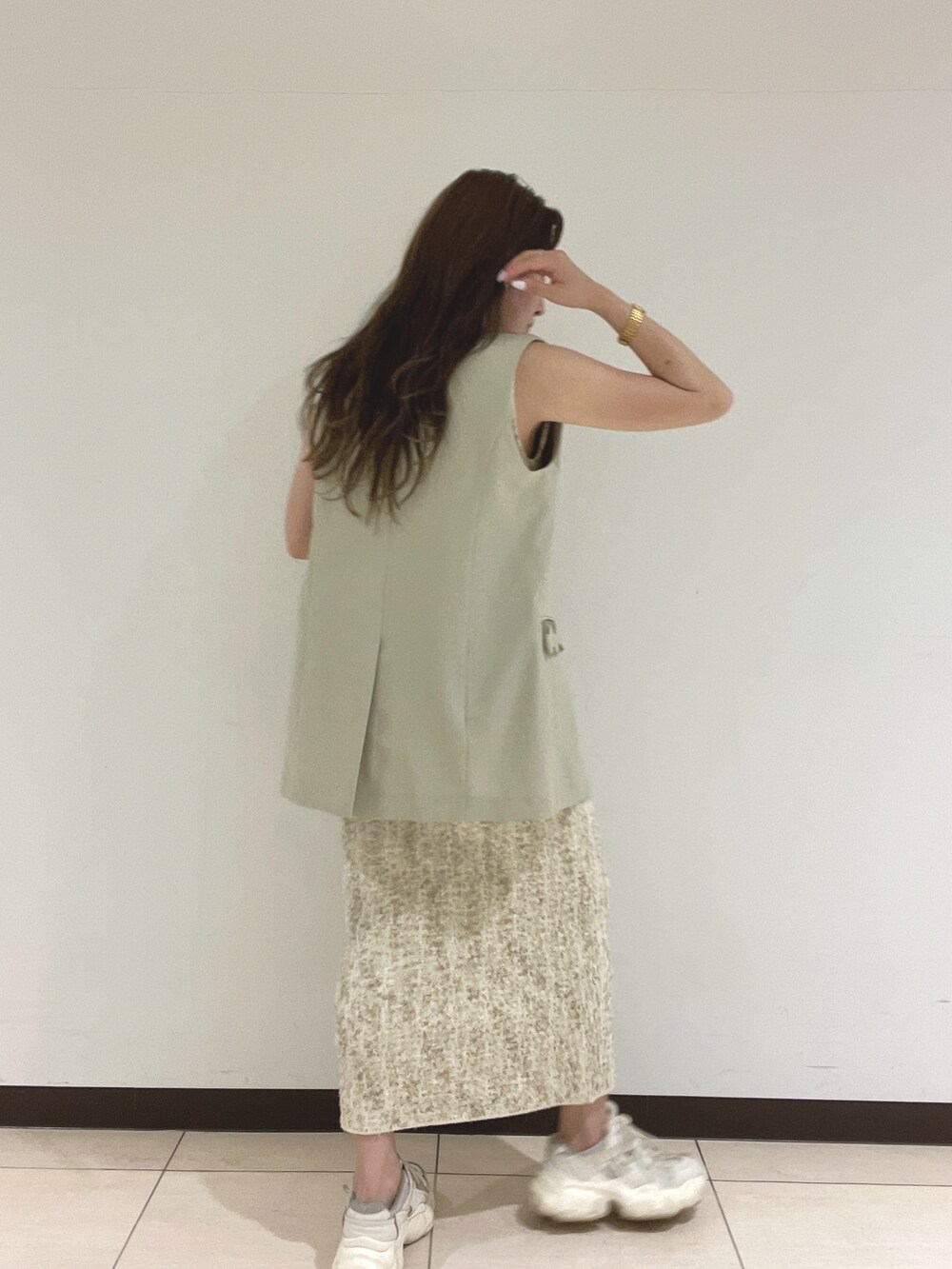 ホワイト系のワンピース、ベージュ系のベストを着用したレディースの春コーディネートの9枚目の写真