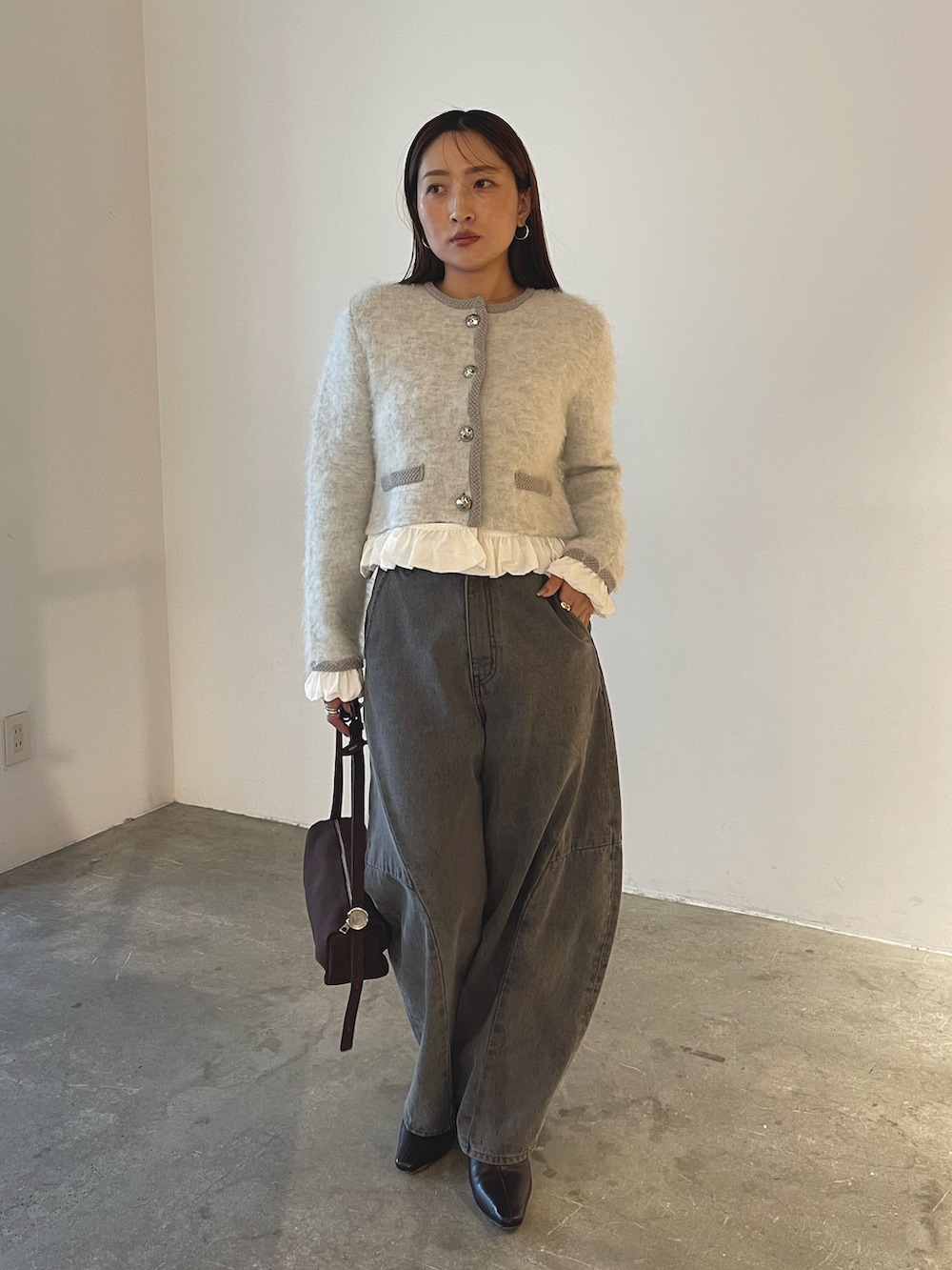 ブラウン系のハンドバッグ、グレー系のデニムパンツ、グレー系のノーカラージャケットを着用したレディースの秋コーディネートの2枚目の写真