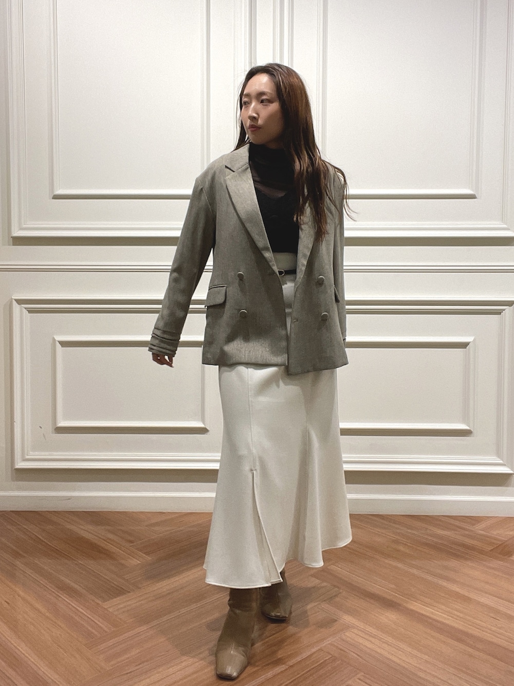 ホワイト系のスカート、ベージュ系のテーラードジャケット、ブラック系のニット/セーターを着用したレディースの秋コーディネートの2枚目の写真