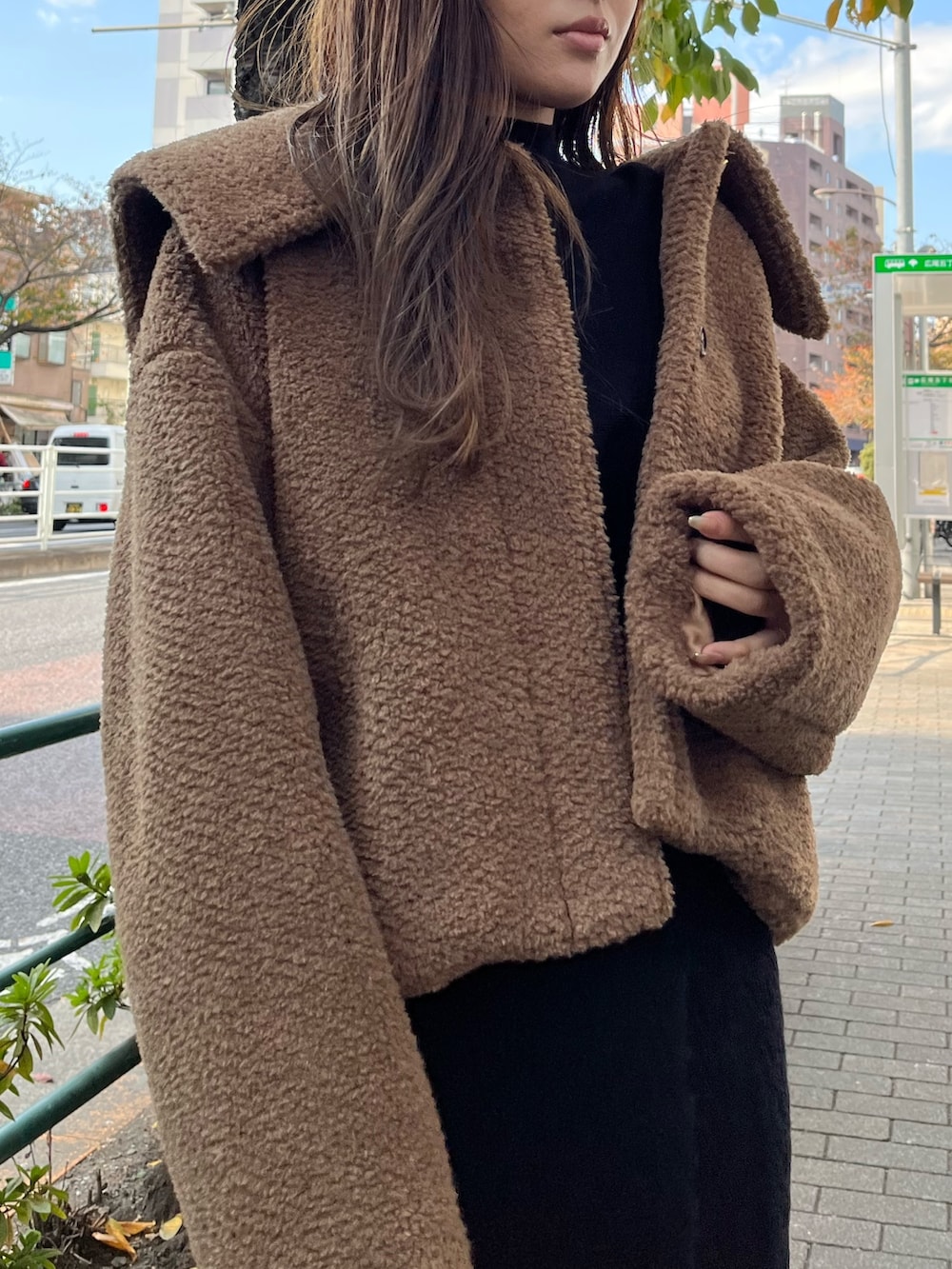 ブラウン系のブルゾン、レッド系のブーツ、ブラック系のワンピースを着用したレディースの秋コーディネートの4枚目の写真