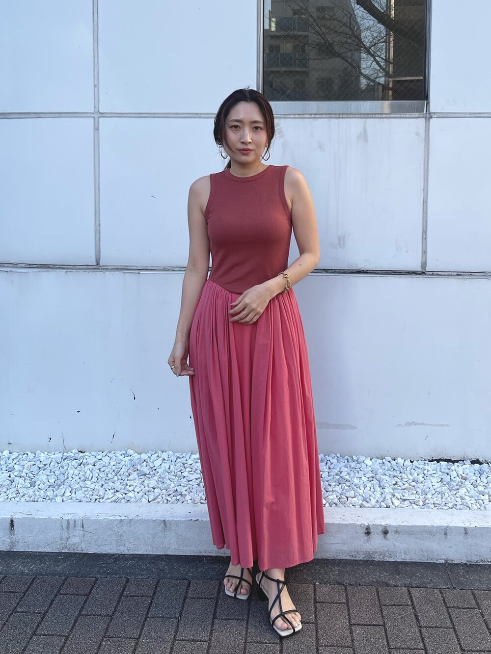 ブラック系のサンダル、ピンク系のワンピースを着用したレディースの春コーディネートの2枚目の写真