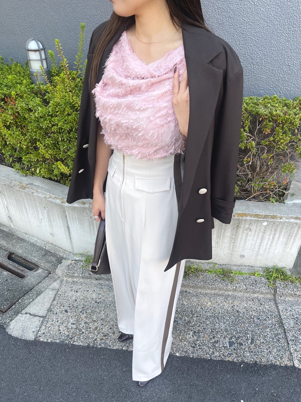 ブラウン系のハンドバッグ、ピンク系のシャツ/ブラウス、ブラック系のパンプスを着用したレディースの冬コーディネートの9枚目の写真