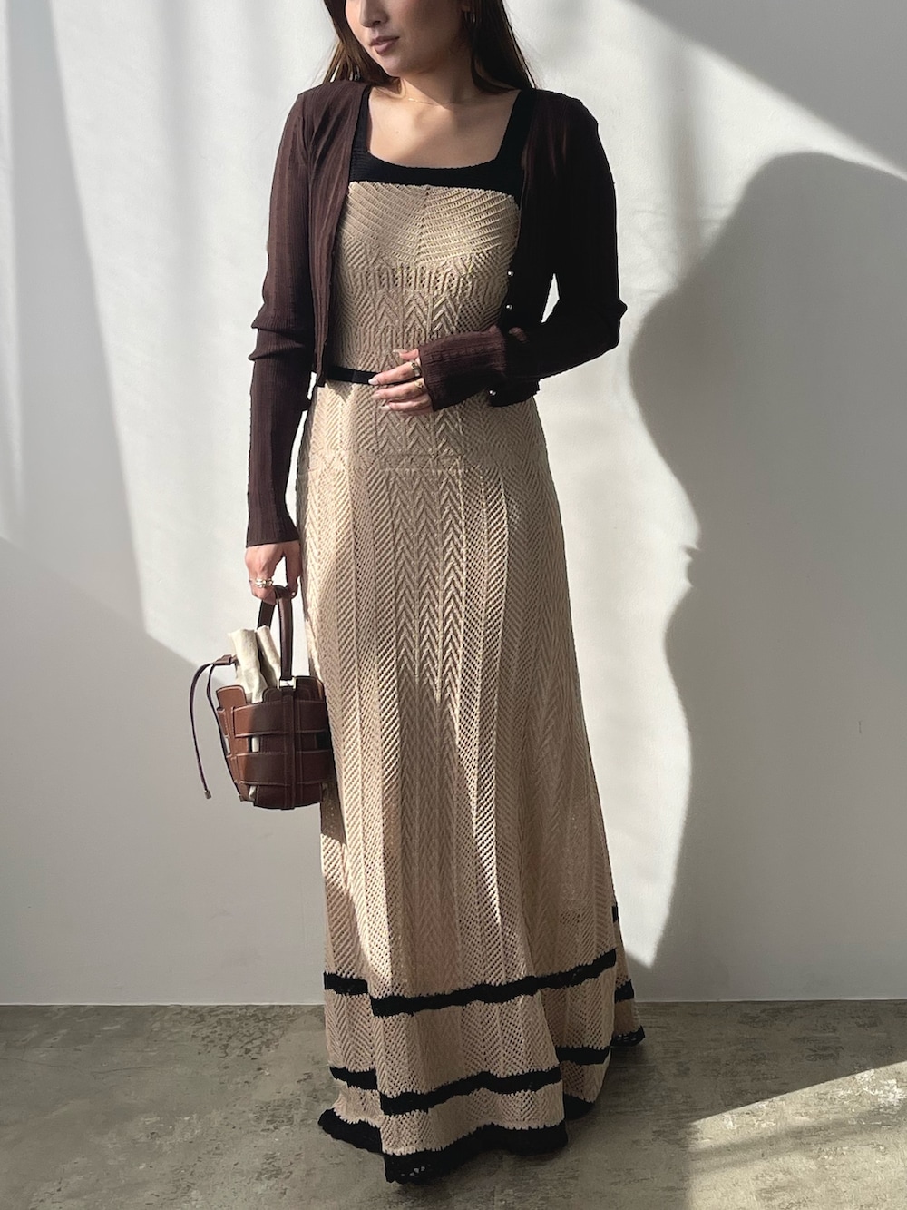 ベージュ系のワンピース、ブラウン系のカーディガン/ボレロ、シルバー系のパンプスを着用したレディースの春コーディネートの2枚目の写真