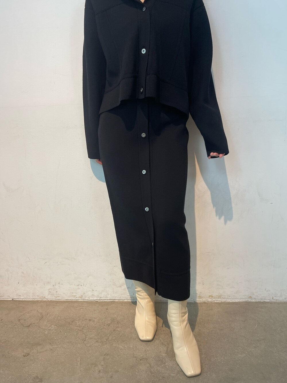 ブラック系のカーディガン/ボレロ、ブラック系のスカート、ホワイト系のブーツを着用したレディースの夏コーディネートの7枚目の写真