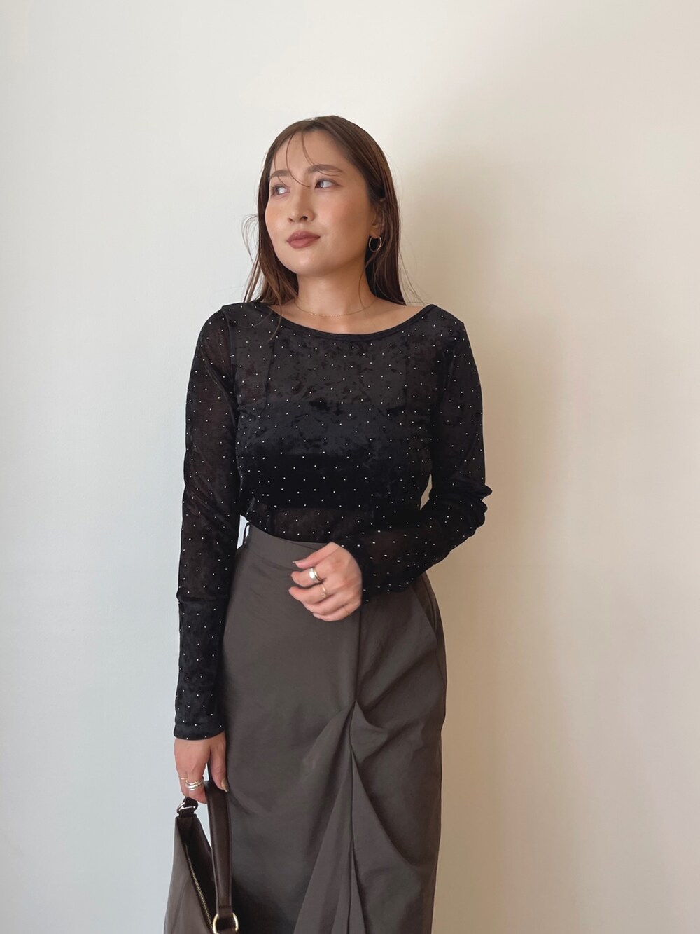 ブラック系のTシャツ/カットソー、ブラウン系のハンドバッグ、ブラウン系のスカートを着用したレディースの秋コーディネートの3枚目の写真