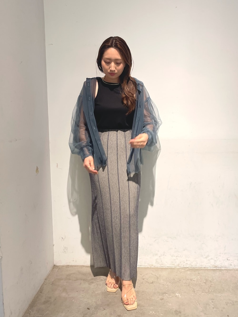 ブルー系のシャツ/ブラウス、グレー系のスカート、ブラック系のTシャツ/カットソーを着用したレディースの春コーディネートの5枚目の写真