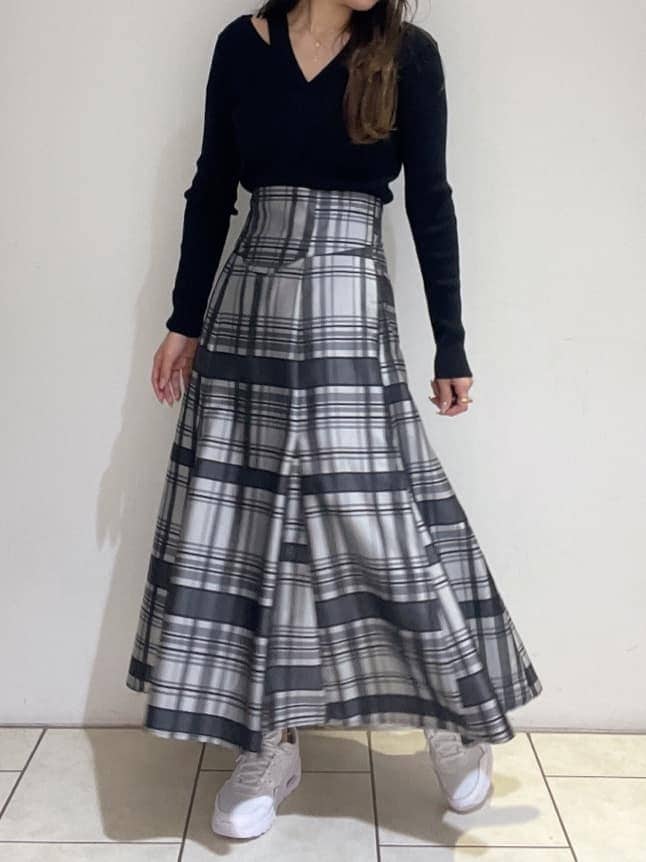 ブラック系のニット/セーター、ホワイト系のスニーカー、ブラック系のスカートを着用したレディースの秋コーディネートの7枚目の写真