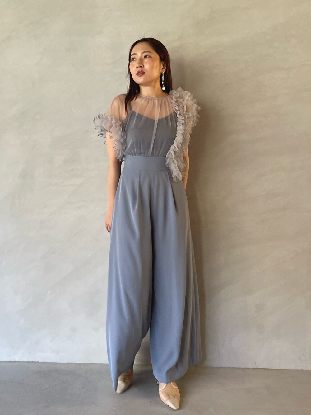 ブルー系のパンツドレス、ゴールド系のピアス（両耳用）を着用したレディースの夏コーディネートの7枚目の写真