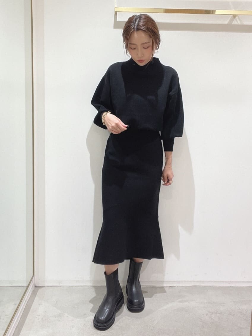 ブラック系のブーツ、ブラック系のニット/セーター、ブラック系のスカートを着用したレディースの秋コーディネートの9枚目の写真