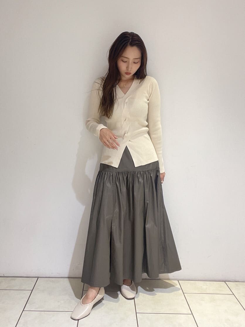 ベージュ系のスカート、ホワイト系のパンプス、ホワイト系のニット/セーターを着用したレディースの夏コーディネートの9枚目の写真