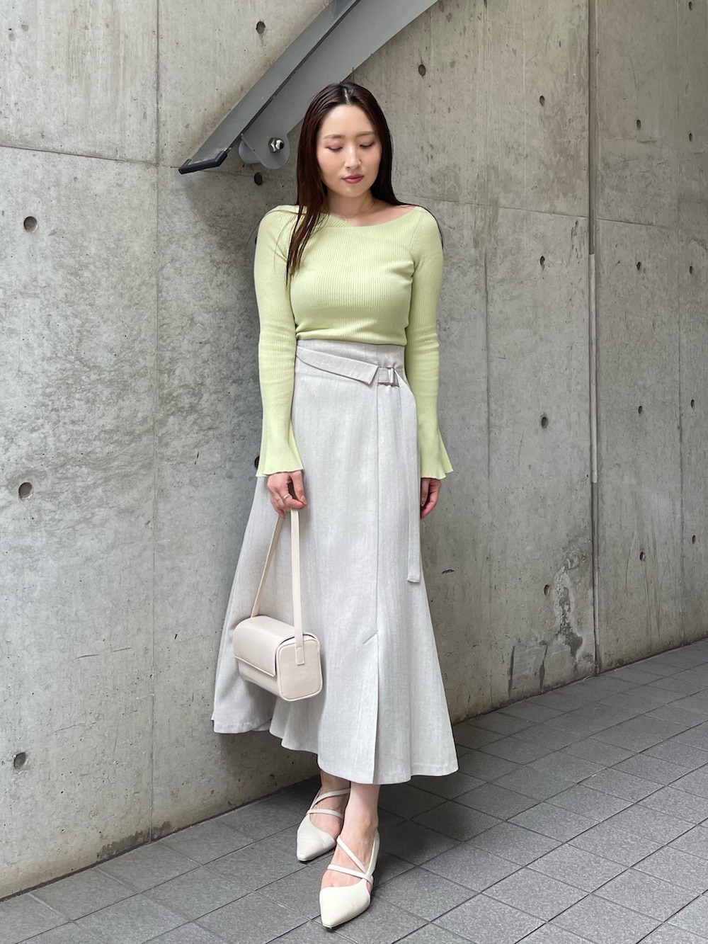 ホワイト系のショルダーバッグ、ホワイト系のパンプス、グレー系のスカートを着用したレディースの秋コーディネートの5枚目の写真