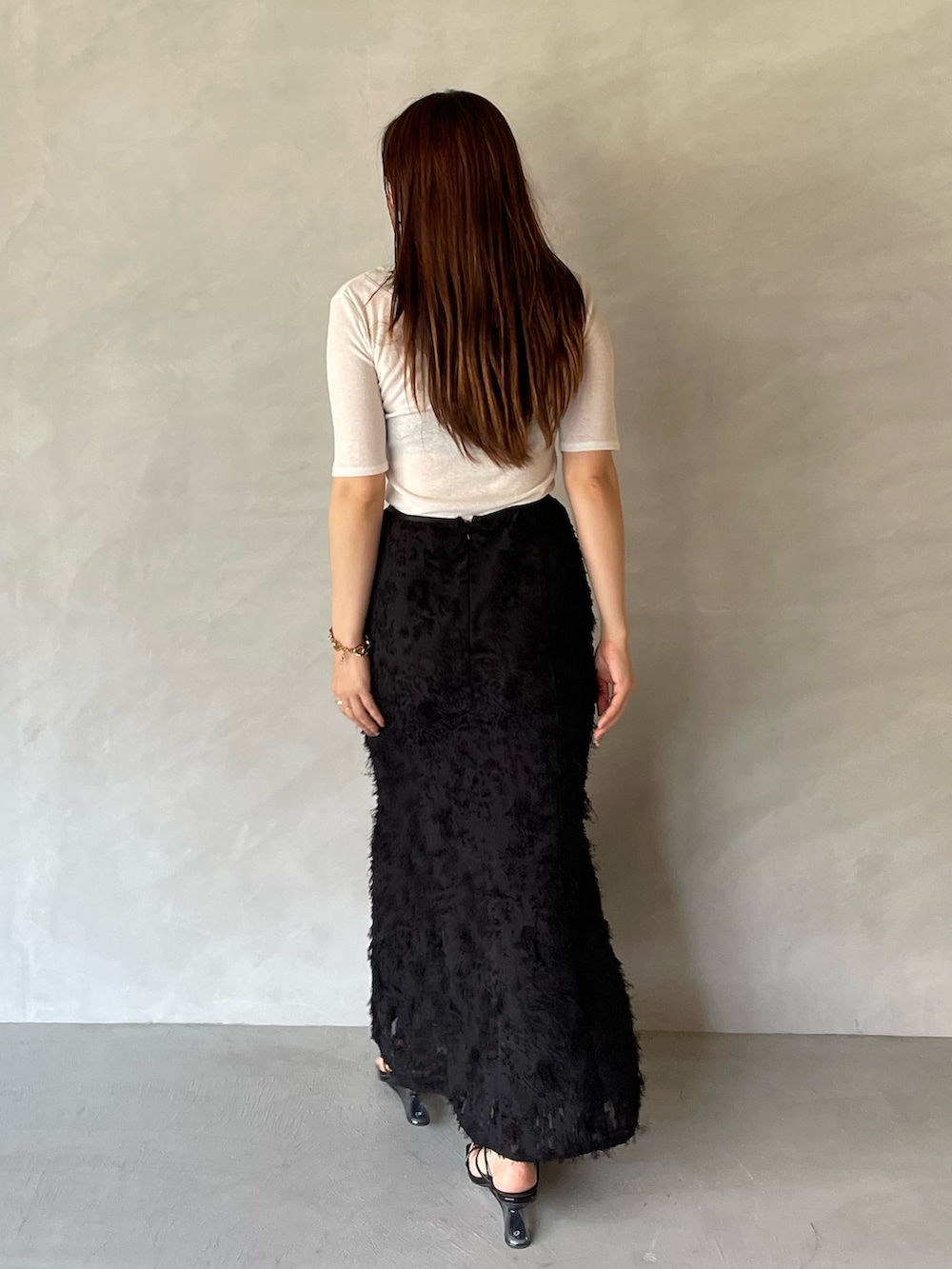 ブラック系のサンダル、ブラック系のスカート、ホワイト系のTシャツ/カットソーを着用したレディースの夏コーディネートの6枚目の写真