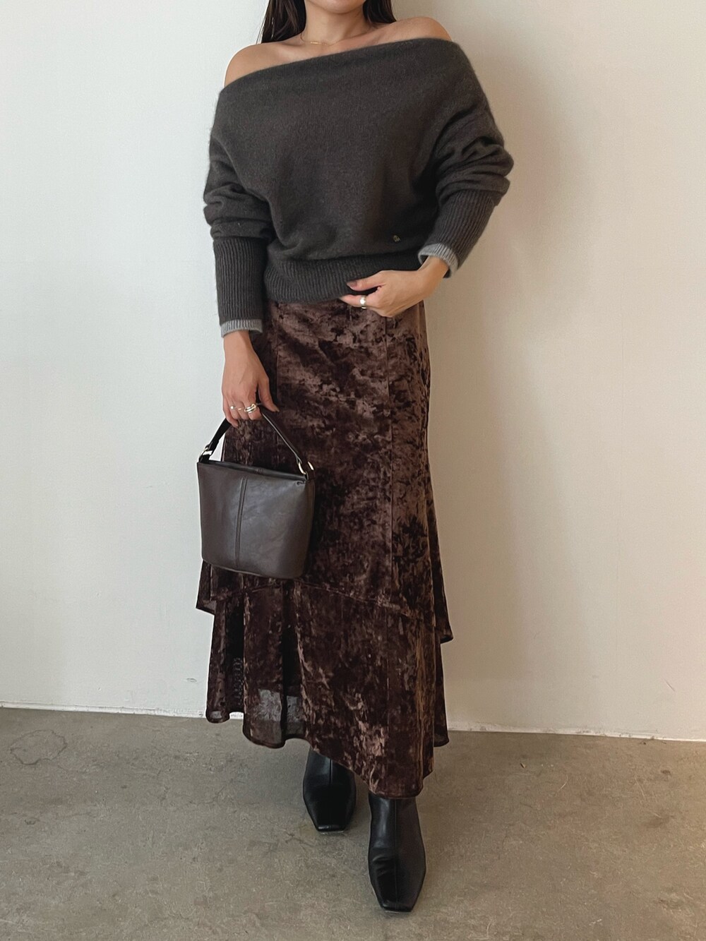 ブラウン系のハンドバッグ、ブラウン系のニット/セーター、ブラウン系のスカートを着用したレディースの秋コーディネートの3枚目の写真