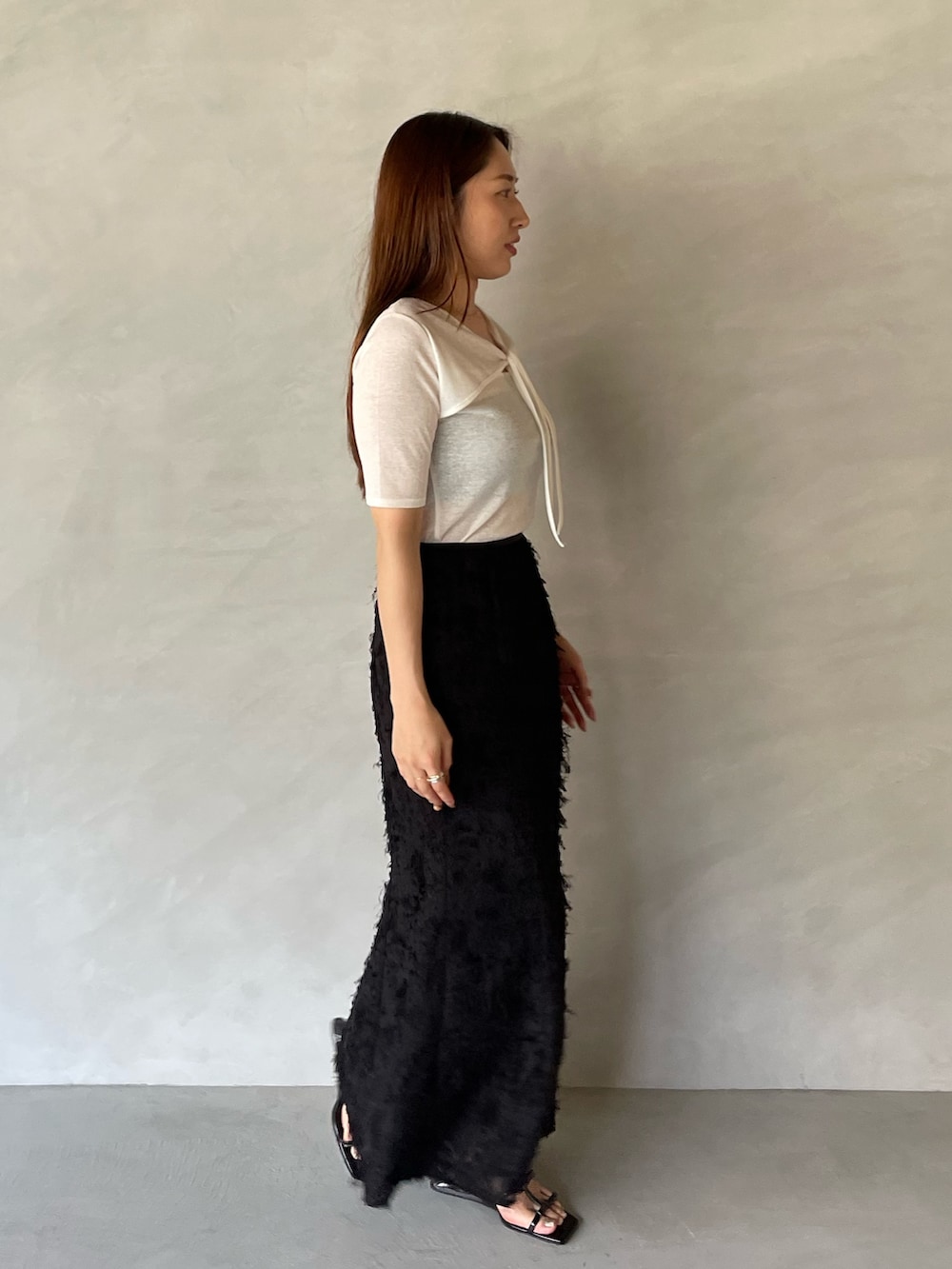 ブラック系のサンダル、ブラック系のスカート、ホワイト系のTシャツ/カットソーを着用したレディースの夏コーディネートの5枚目の写真