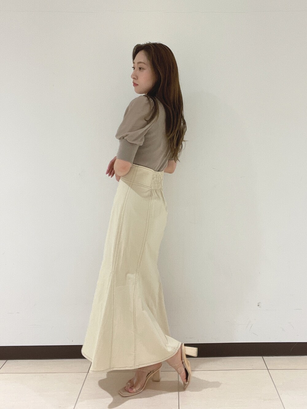 ホワイト系のスカート、その他のサンダル、ブラウン系のニット/セーターを着用したレディースの春コーディネートの5枚目の写真