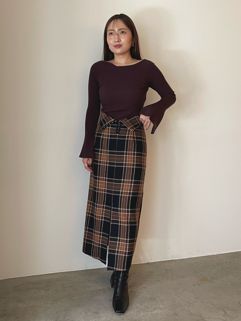 ブラック系のブーツ、ブラウン系のスカート、ブラウン系のニット/セーターを着用したレディースの秋コーディネートの5枚目の写真