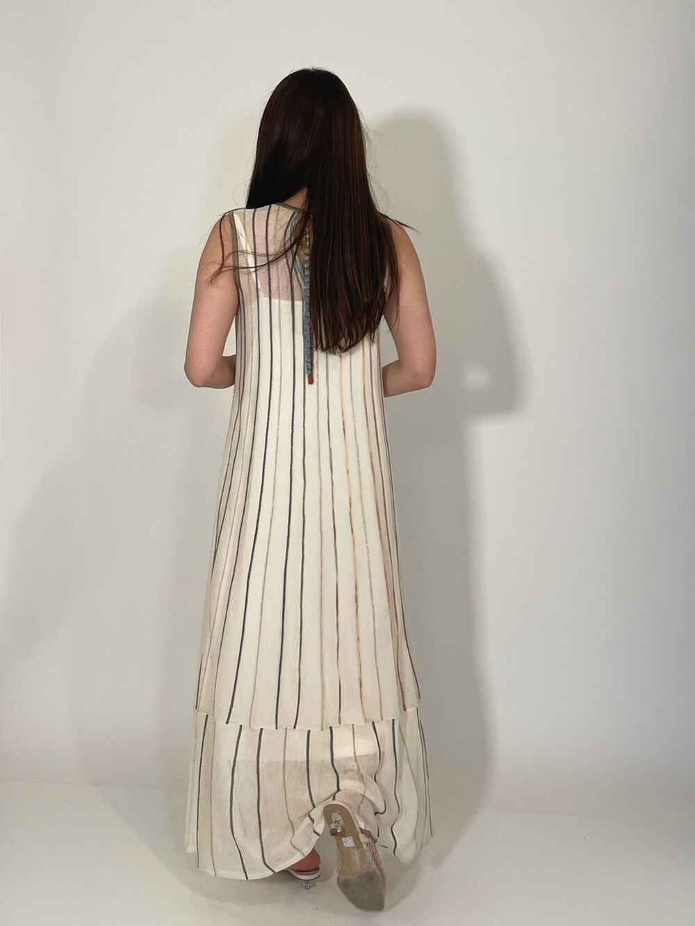 ホワイト系のサンダル、ホワイト系のワンピース、ゴールド系のブレスレットを着用したレディースの夏コーディネートの6枚目の写真