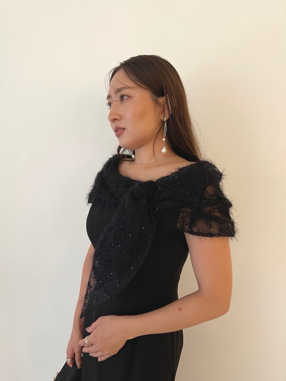 シルバー系のパンプス、ブラック系のハンドバッグ、ブラック系のドレスを着用したレディースの秋コーディネートの10枚目の写真