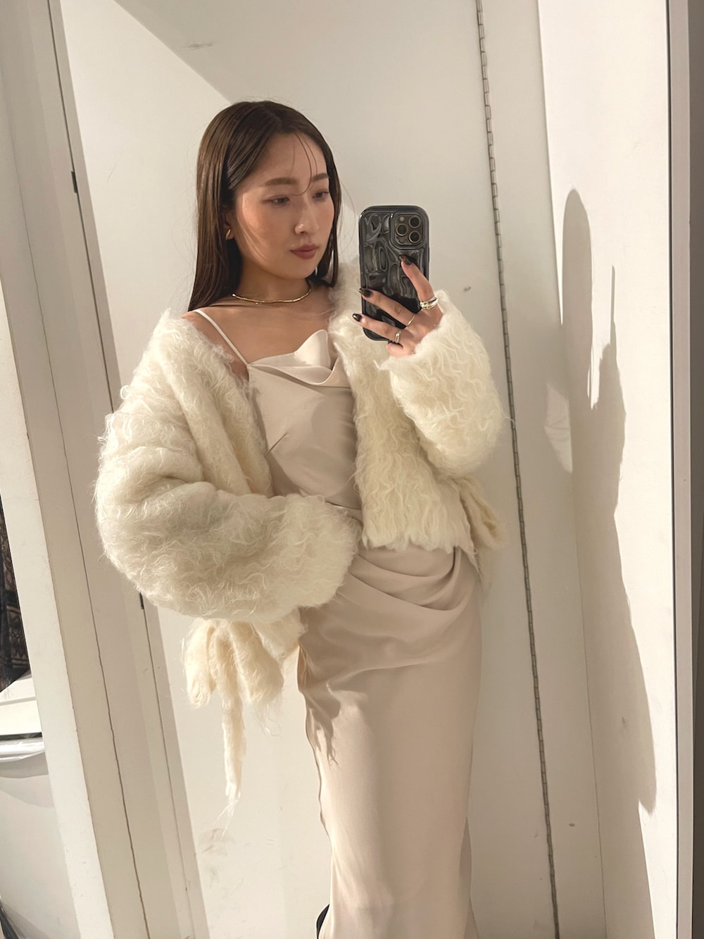 ベージュ系のワンピース、ブラウン系のハンドバッグ、ブラウン系のブーツを着用したレディースの冬コーディネートの10枚目の写真