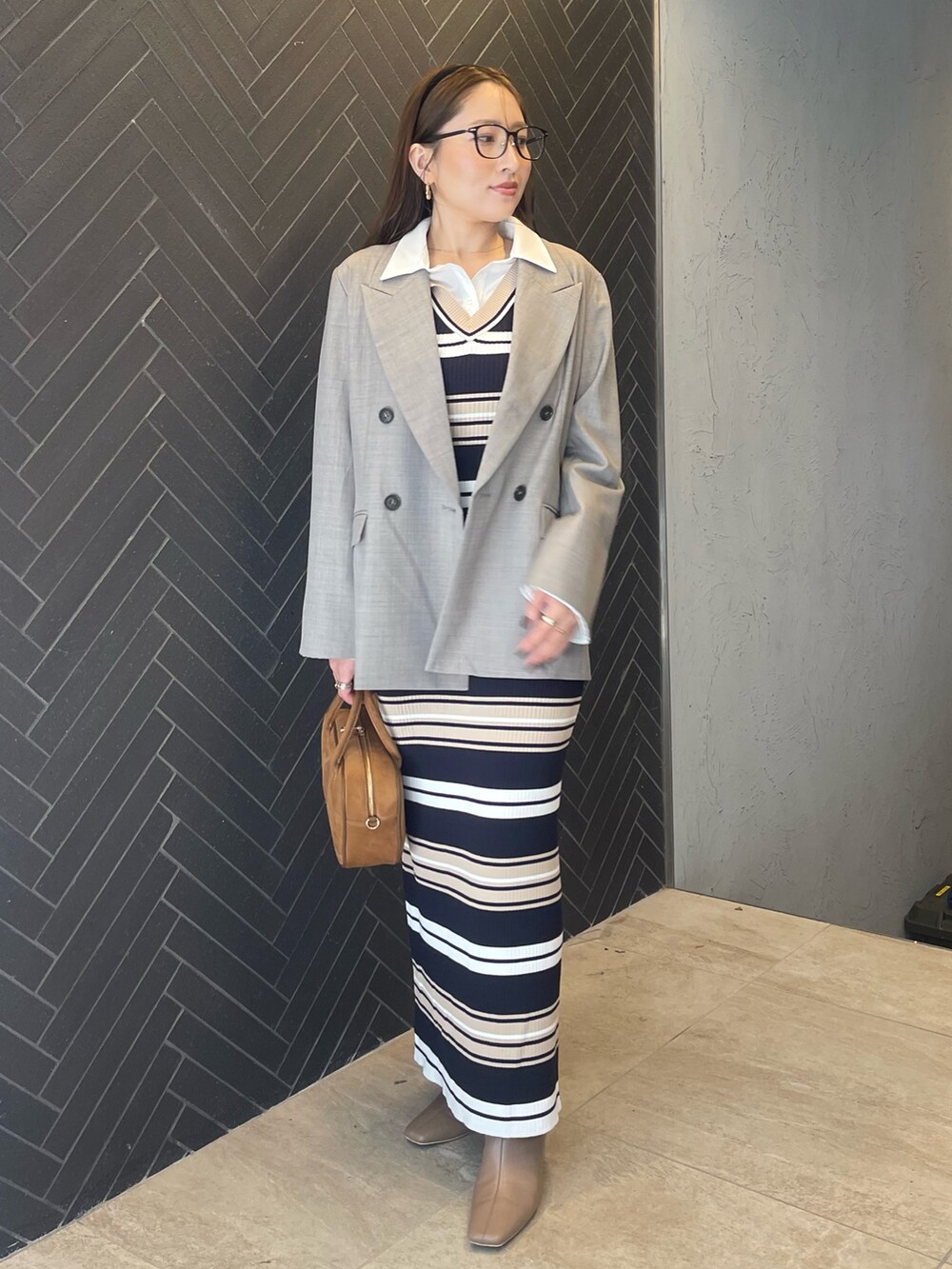 イエロー系のハンドバッグ、ベージュ系のワンピース、グレー系のテーラードジャケットを着用したレディースの冬コーディネートの2枚目の写真