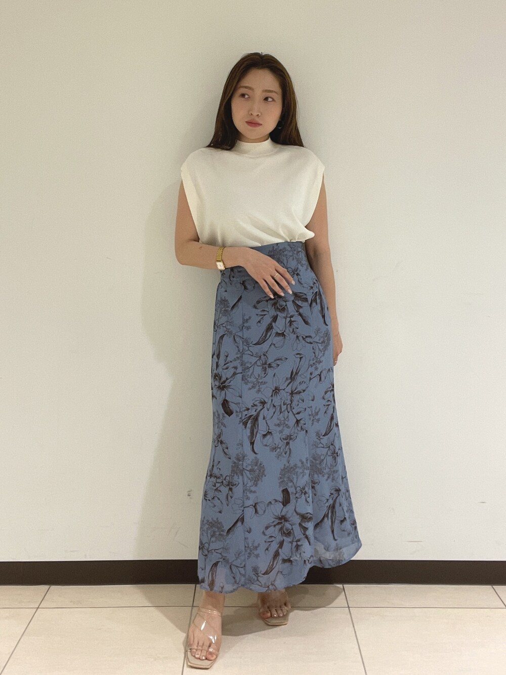 ブルー系のスカート、ホワイト系のニット/セーターを着用したレディースの夏コーディネートの2枚目の写真