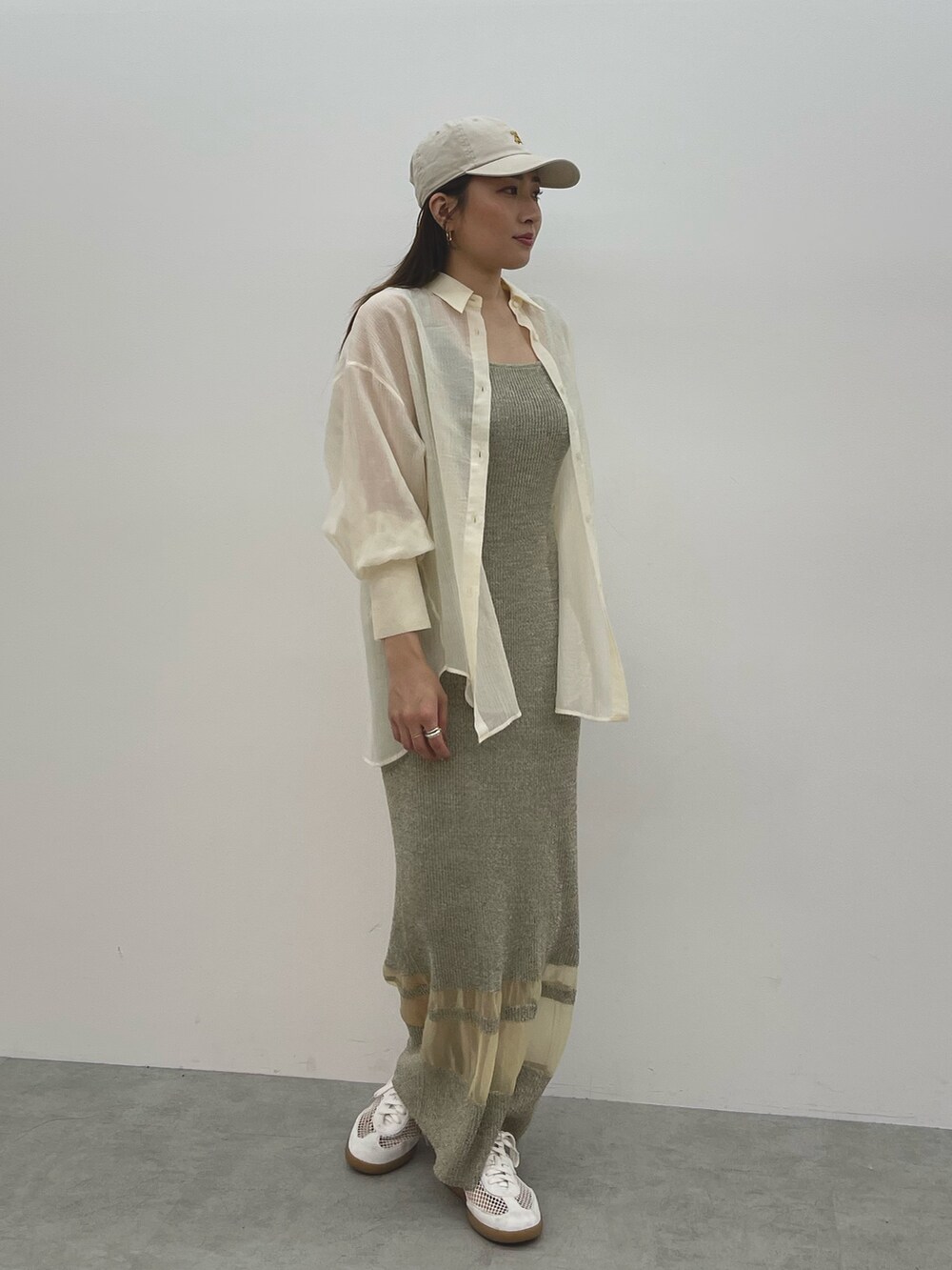 ベージュ系のワンピース、ホワイト系のスニーカー、ホワイト系のシャツ/ブラウスを着用したレディースの春コーディネートの2枚目の写真