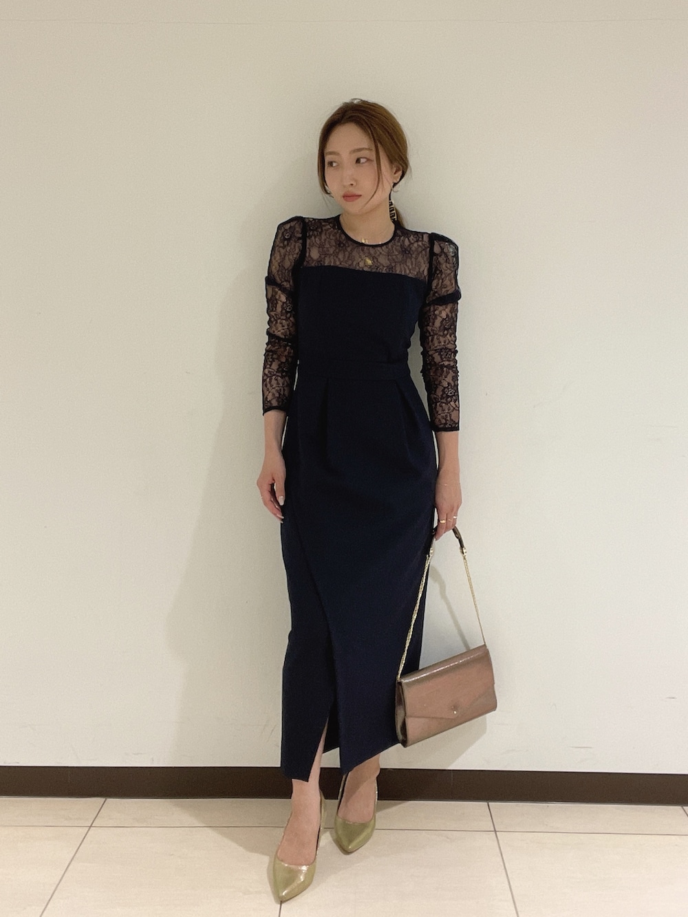 ゴールド系のハンドバッグ、ゴールド系のパンプス、ブルー系のドレスを着用したレディースの夏コーディネートの3枚目の写真