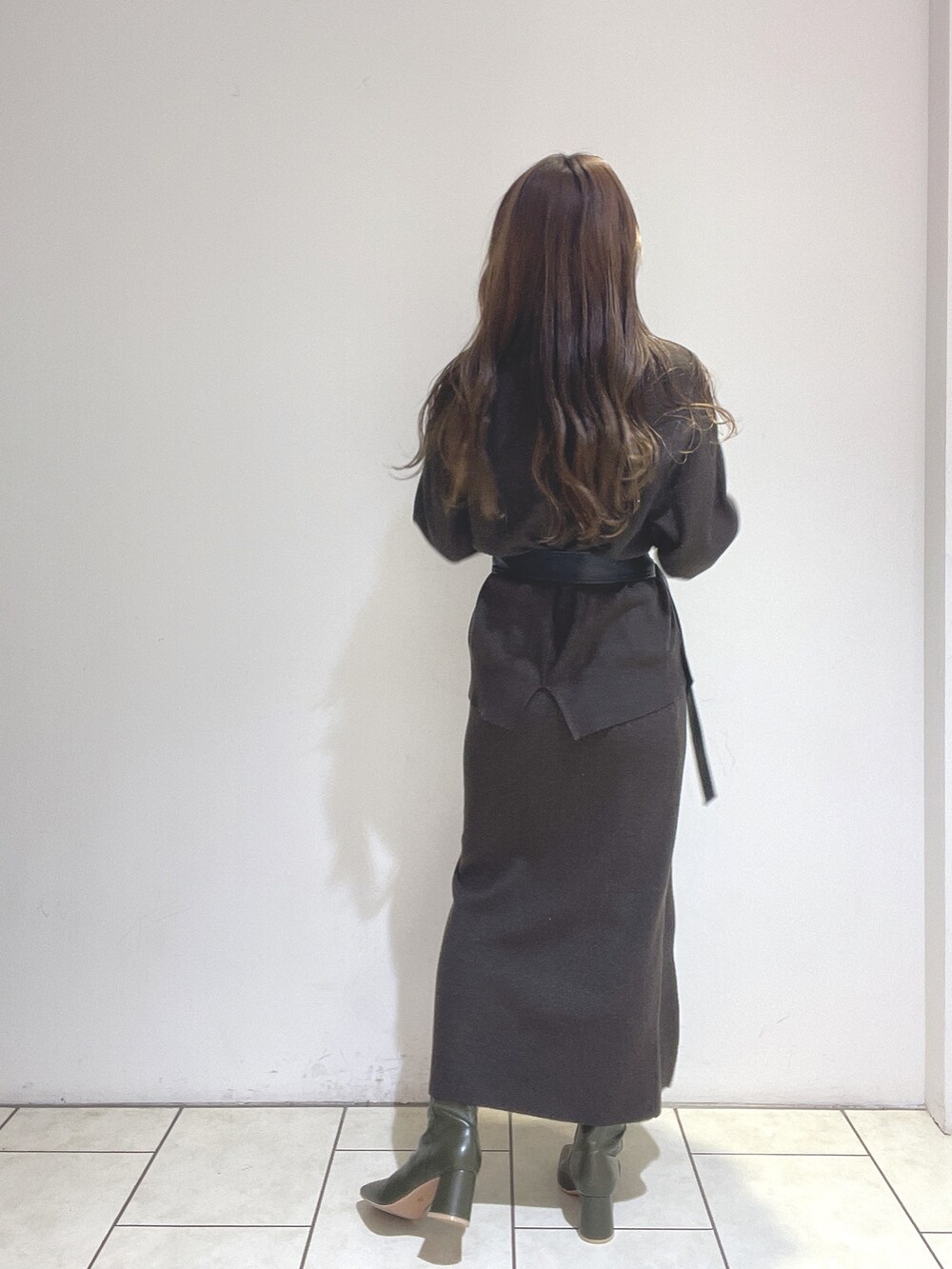 ブラウン系のニット/セーター、ブラウン系のスカート、グリーン系のブーツを着用したレディースの冬コーディネートの6枚目の写真