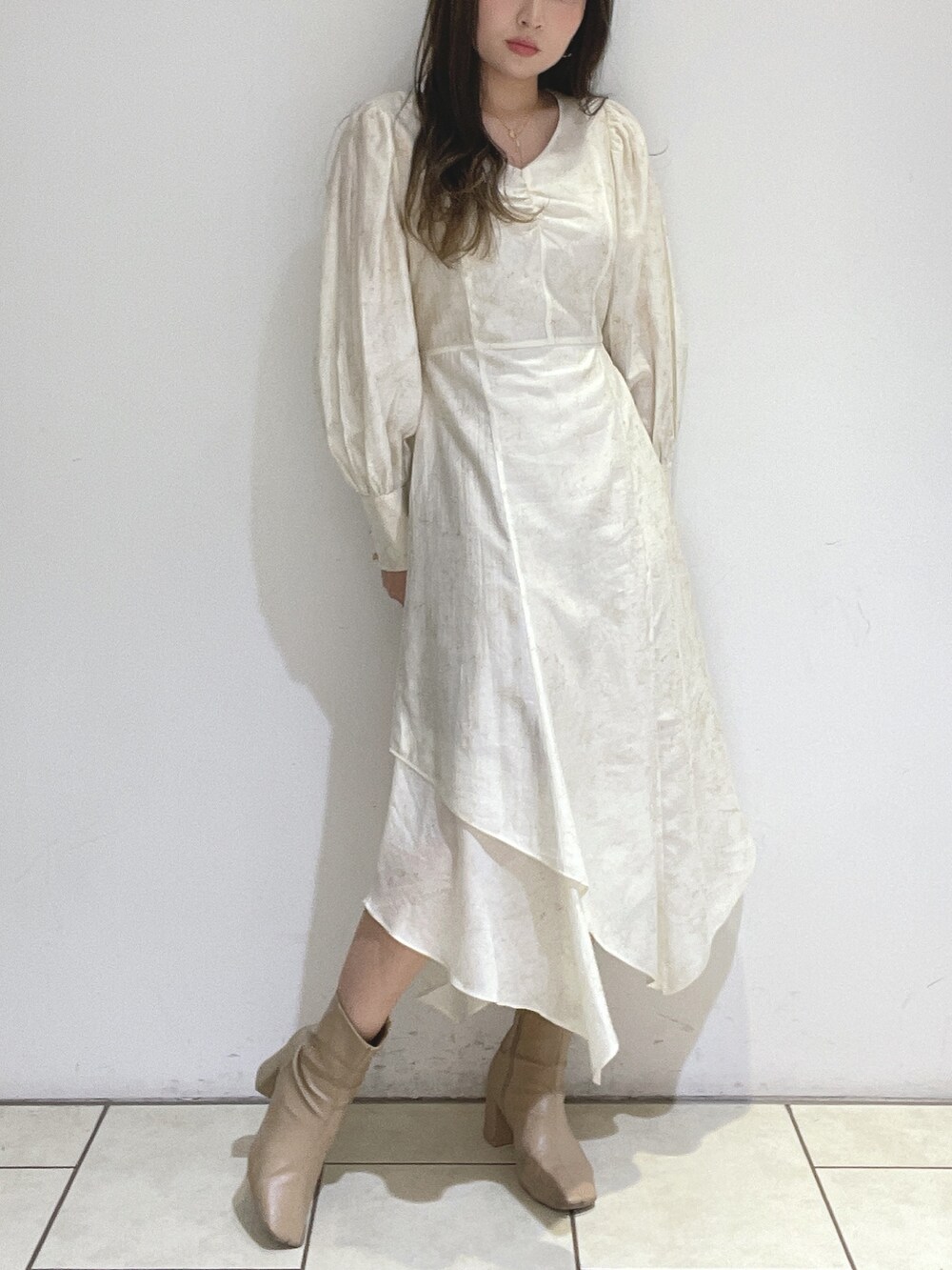 ベージュ系のブーツ、ホワイト系のワンピースを着用したレディースの冬コーディネートの2枚目の写真