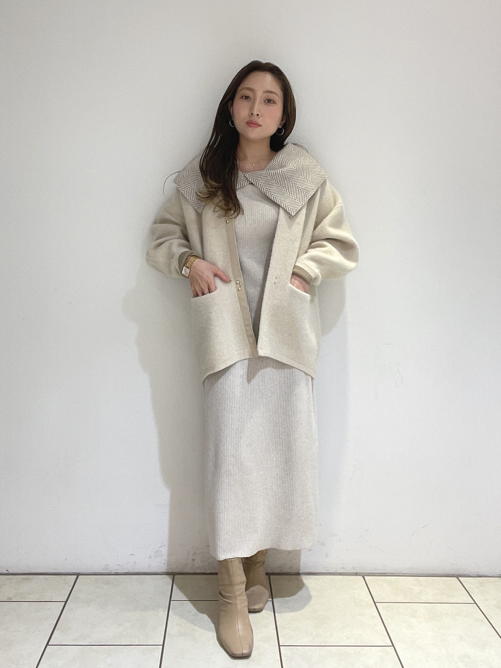 ホワイト系のワンピース、ホワイト系のカーディガン/ボレロ、ベージュ系のブーツを着用したレディースの冬コーディネートの8枚目の写真