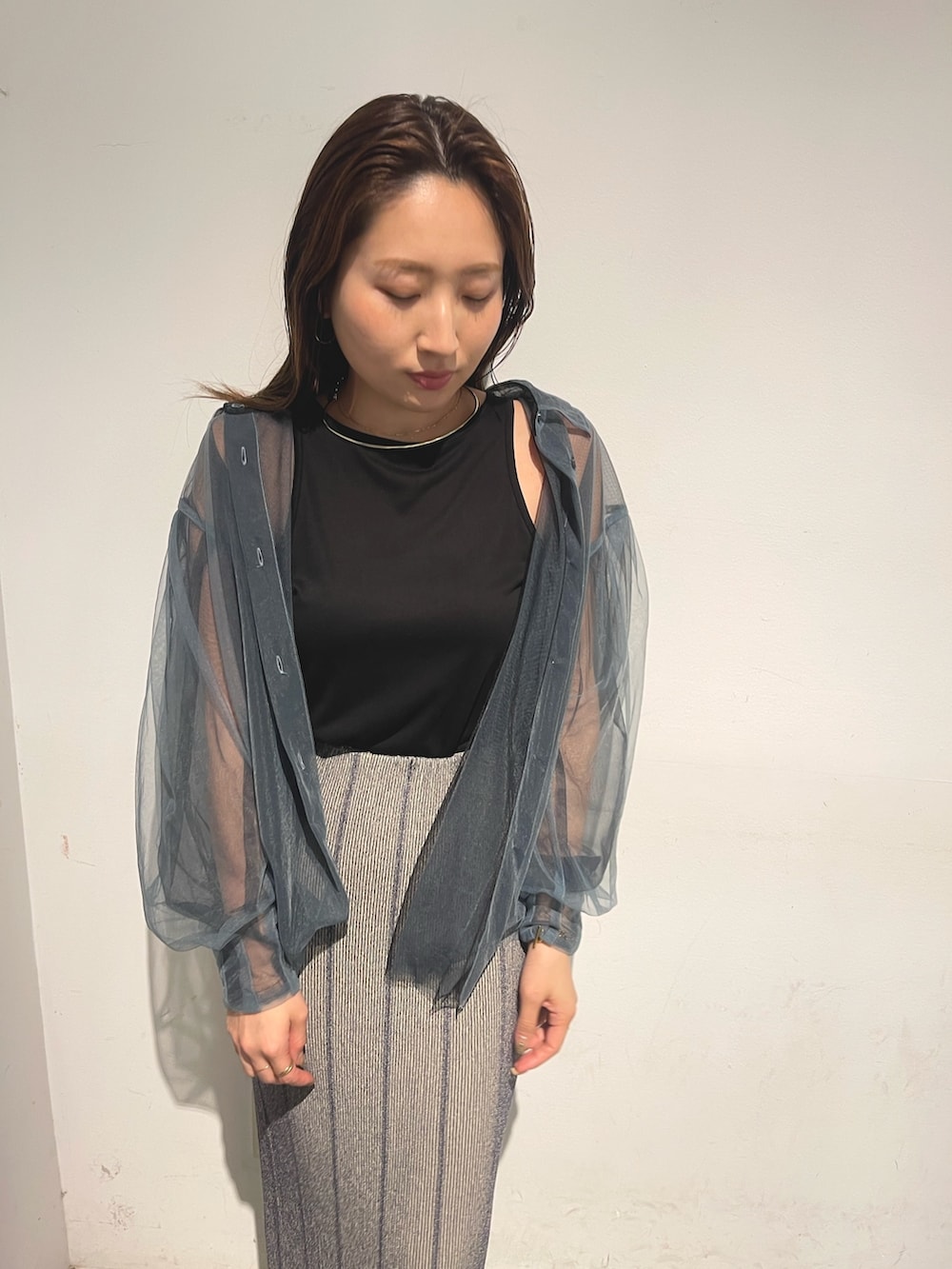 ブルー系のシャツ/ブラウス、グレー系のスカート、ブラック系のTシャツ/カットソーを着用したレディースの春コーディネートの6枚目の写真