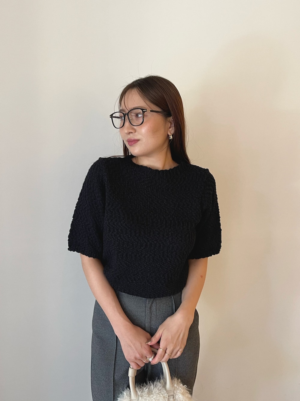 ホワイト系のボストンバッグ、ブラック系のブーツ、ブラック系のニット/セーターを着用したレディースの夏コーディネートの8枚目の写真