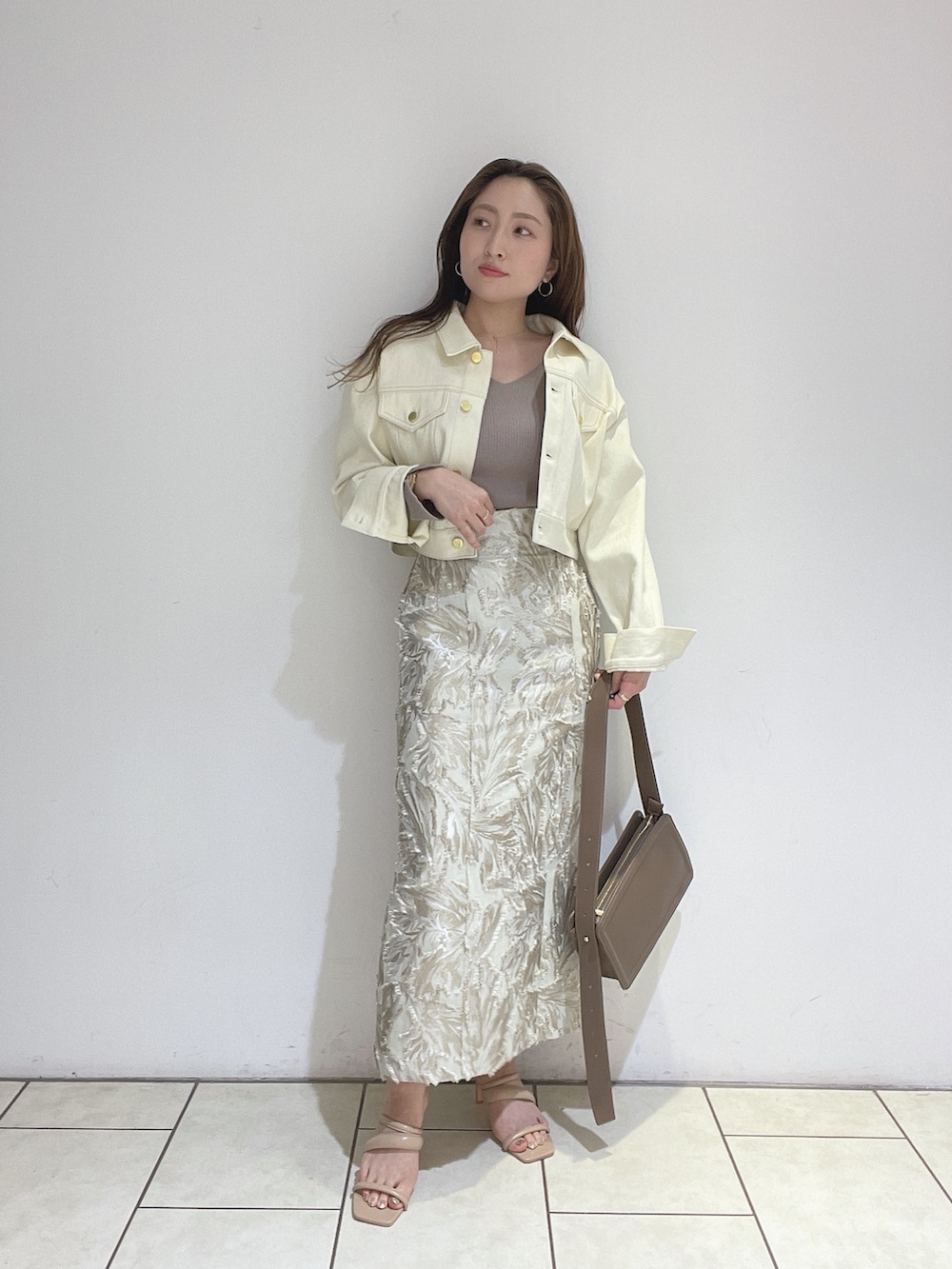 ベージュ系のスカート、ベージュ系のサンダル、ブラウン系のショルダーバッグを着用したレディースの春コーディネートの3枚目の写真