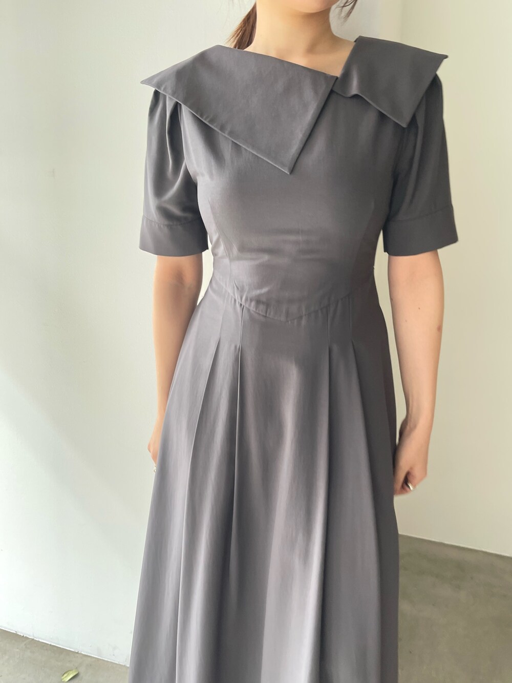 ホワイト系のサンダル、グレー系のワンピース、ゴールド系のピアス（両耳用）を着用したレディースの春コーディネートの8枚目の写真