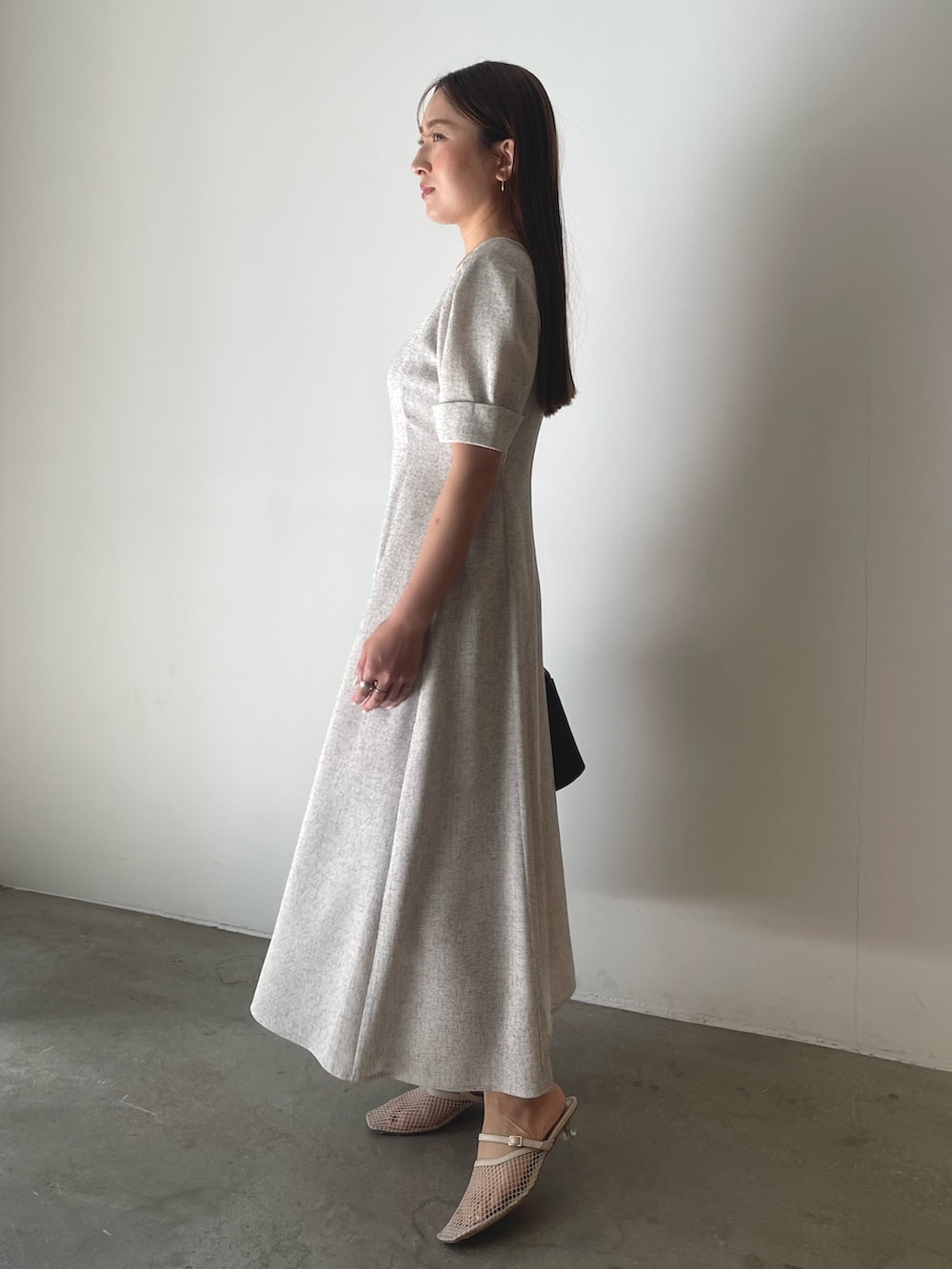 ブラウン系のハンドバッグ、ホワイト系のワンピースを着用したレディースの冬コーディネートの5枚目の写真