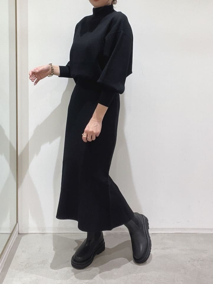 ブラック系のブーツ、ブラック系のニット/セーター、ブラック系のスカートを着用したレディースの秋コーディネートの7枚目の写真
