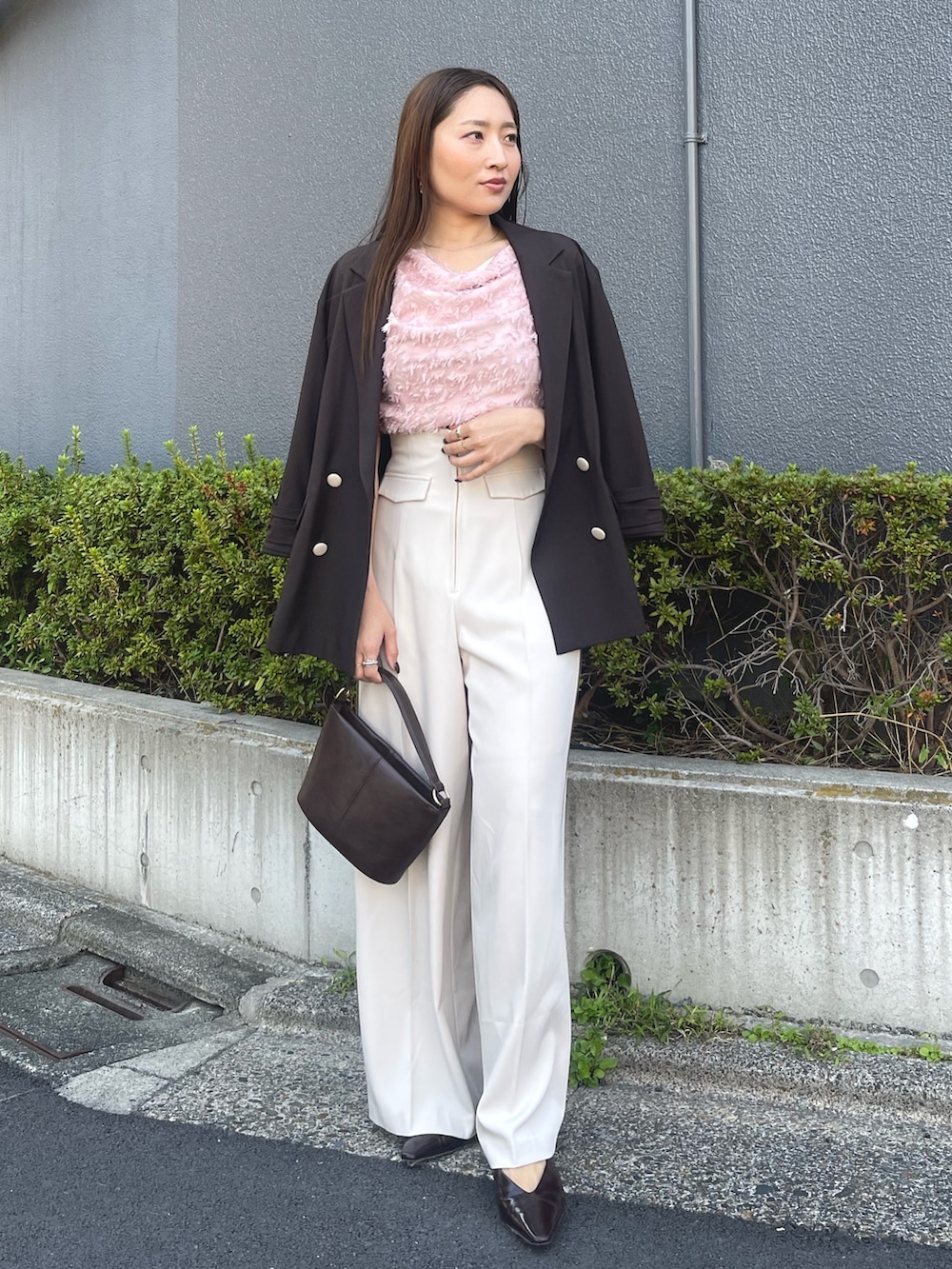 ブラウン系のハンドバッグ、ピンク系のシャツ/ブラウス、ブラック系のパンプスを着用したレディースの冬コーディネートの5枚目の写真