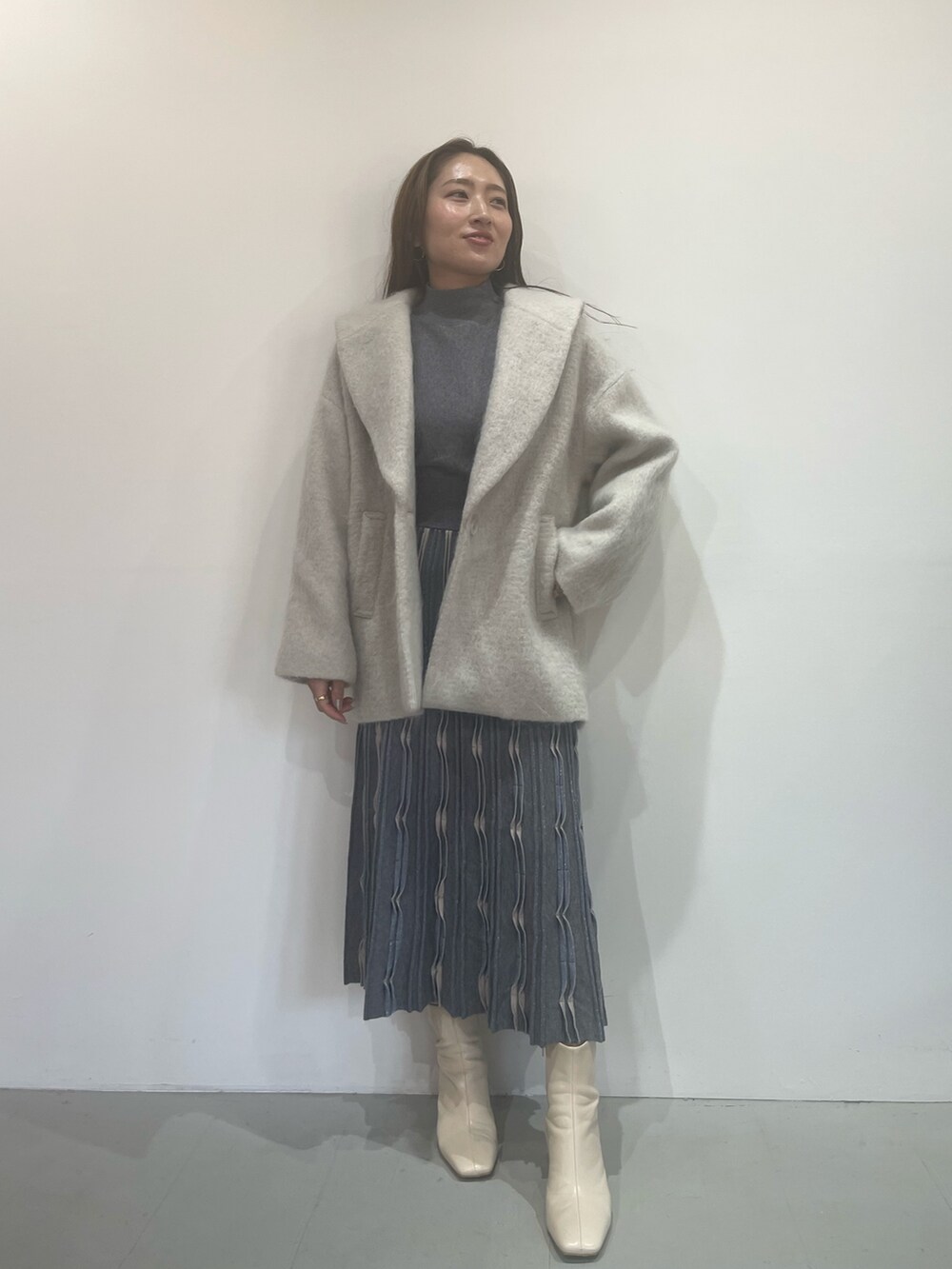 ホワイト系のブーツ、グレー系のワンピース、グレー系のその他アウターを着用したレディースの秋コーディネートの3枚目の写真