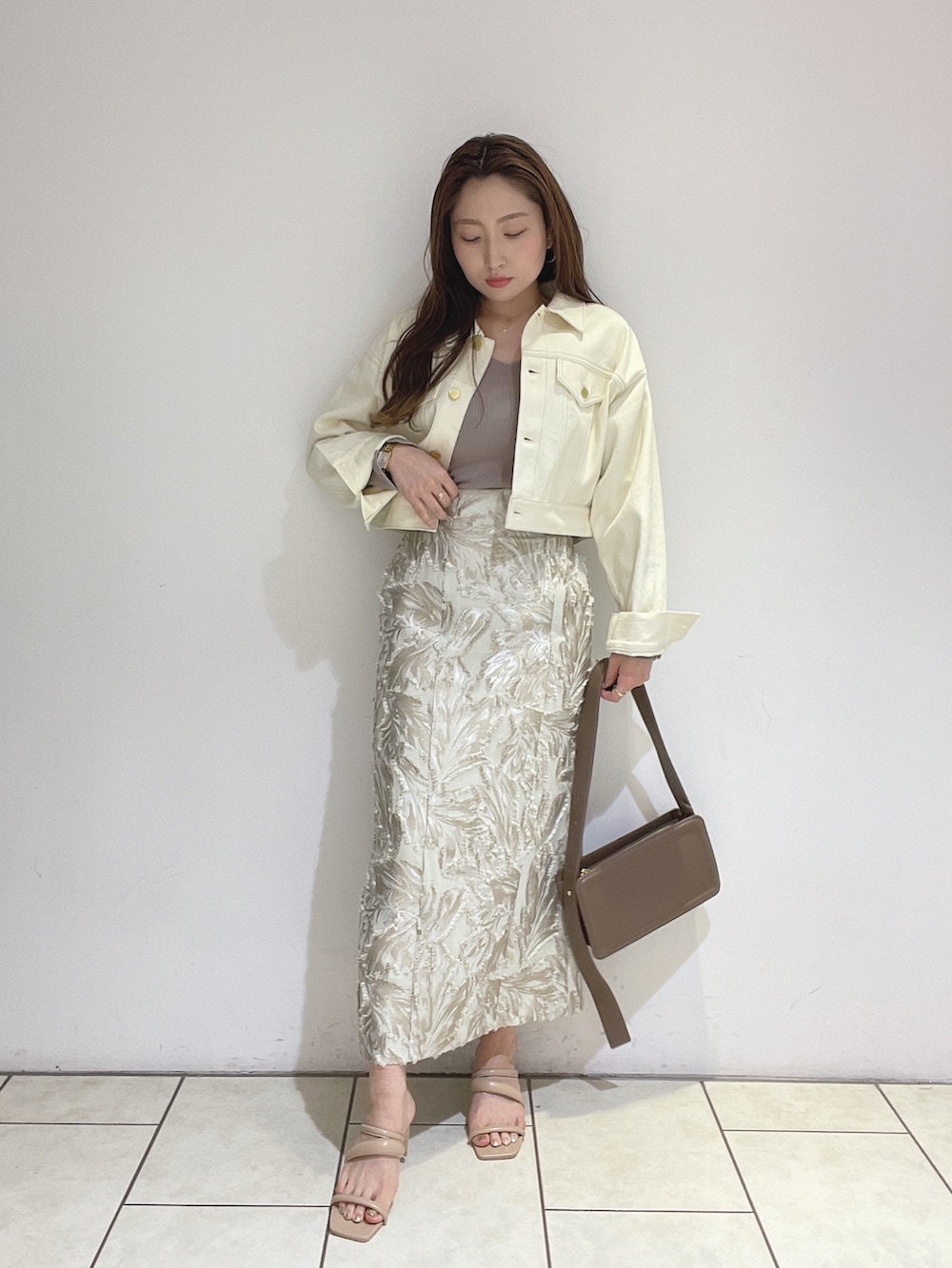 ベージュ系のスカート、ベージュ系のサンダル、ブラウン系のショルダーバッグを着用したレディースの春コーディネートの6枚目の写真