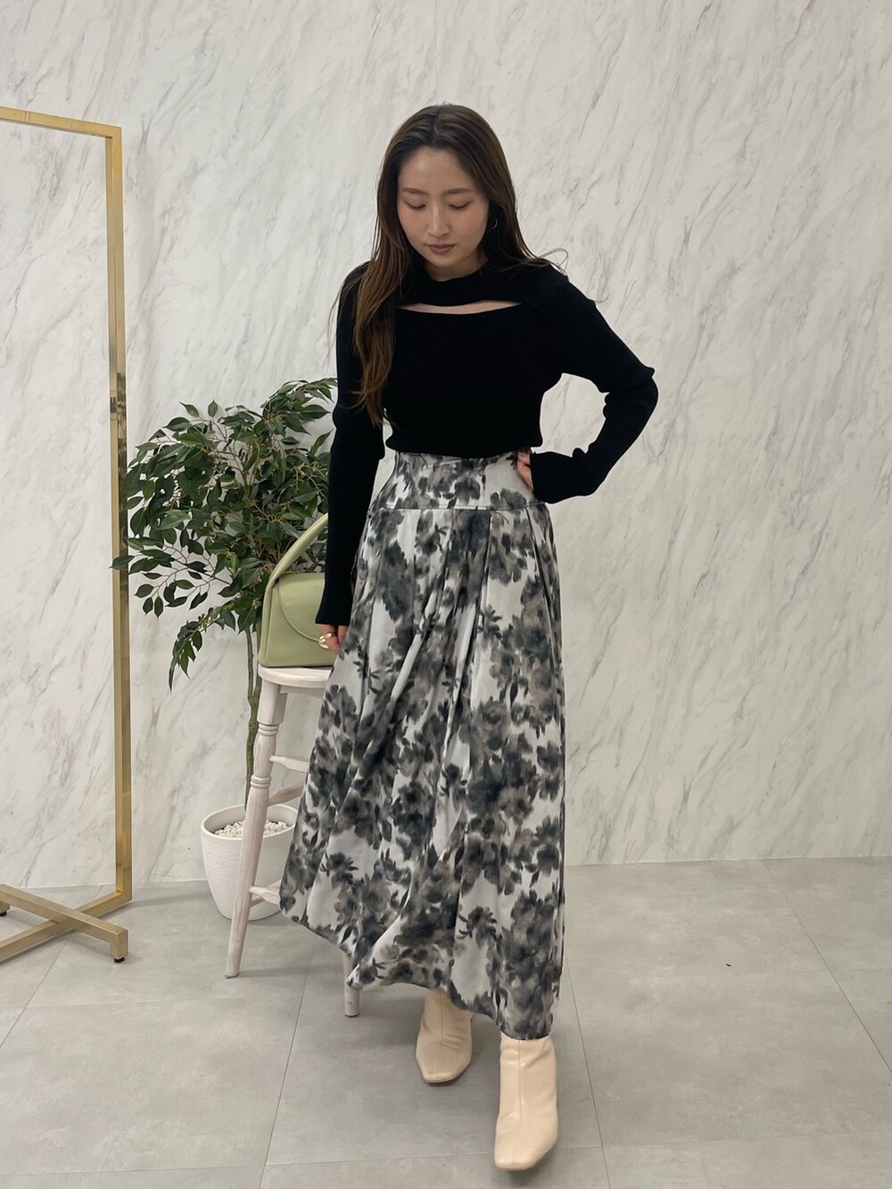 ホワイト系のブーツ、ブラック系のニット/セーター、グリーン系のハンドバッグを着用したレディースの冬コーディネートの4枚目の写真