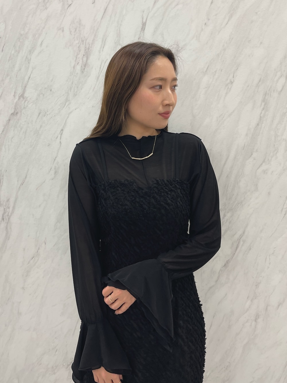 シルバー系のパンプス、ブラック系のワンピース、ゴールド系のネックレスを着用したレディースの春コーディネートの6枚目の写真