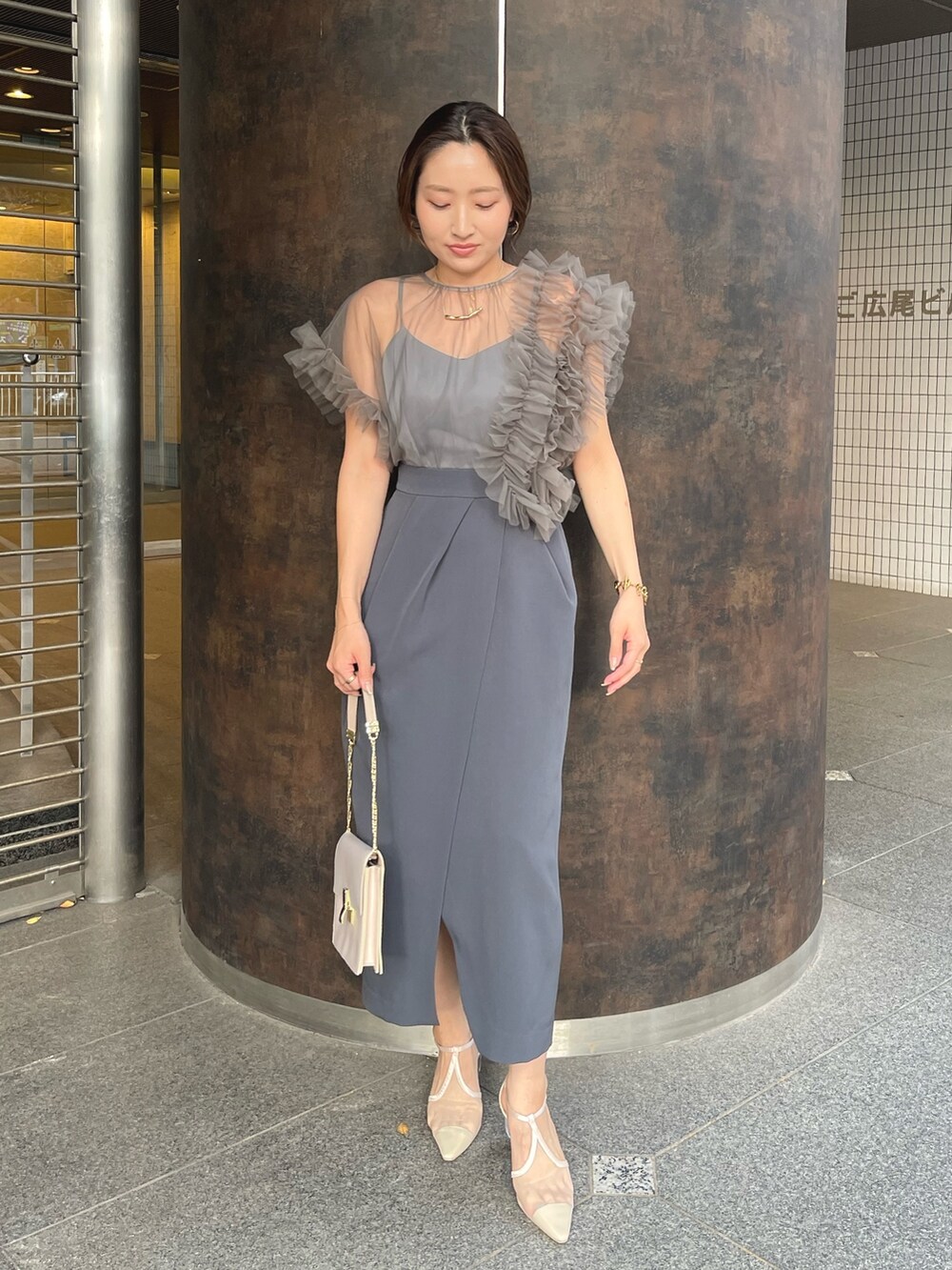 グレー系のドレス、ベージュ系のパンプスを着用したレディースの冬コーディネートの2枚目の写真