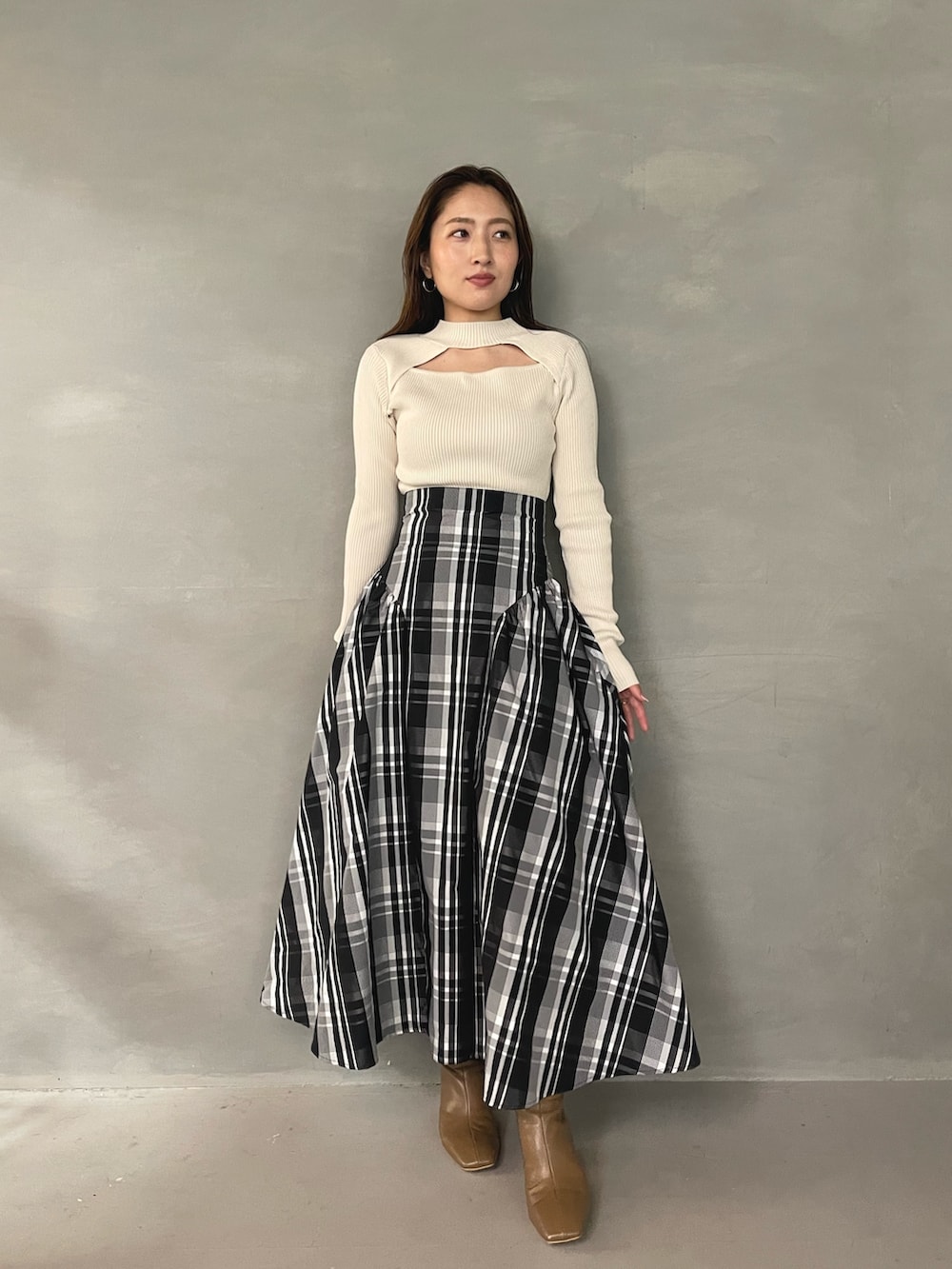 ベージュ系のブーツ、ホワイト系のニット/セーター、ホワイト系のスカートを着用したレディースの秋コーディネートの3枚目の写真