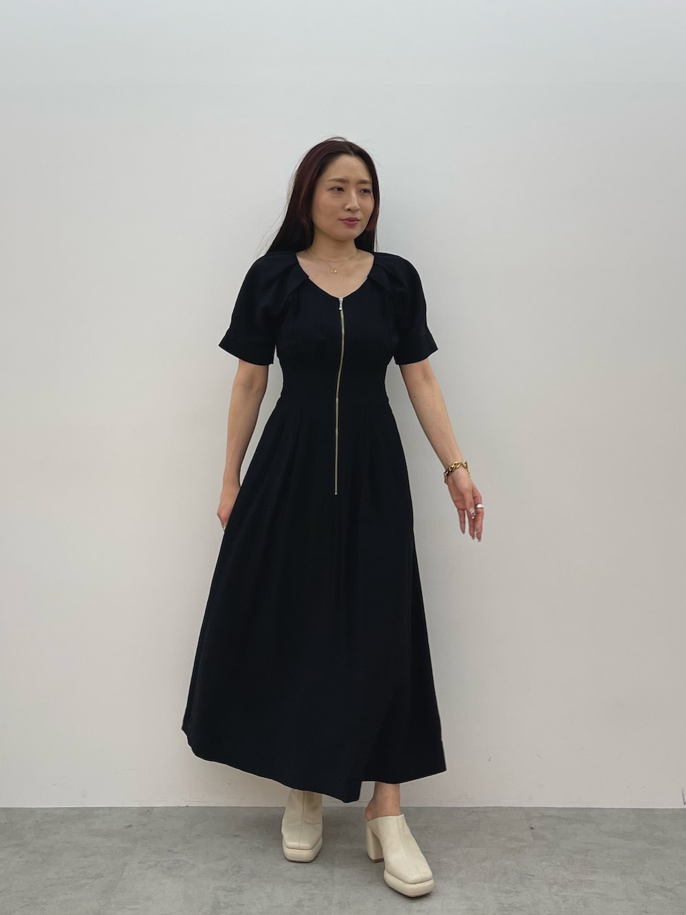 ホワイト系のトレンチコート、ブラック系のワンピース、ホワイト系のサンダルを着用したレディースの春コーディネートの9枚目の写真