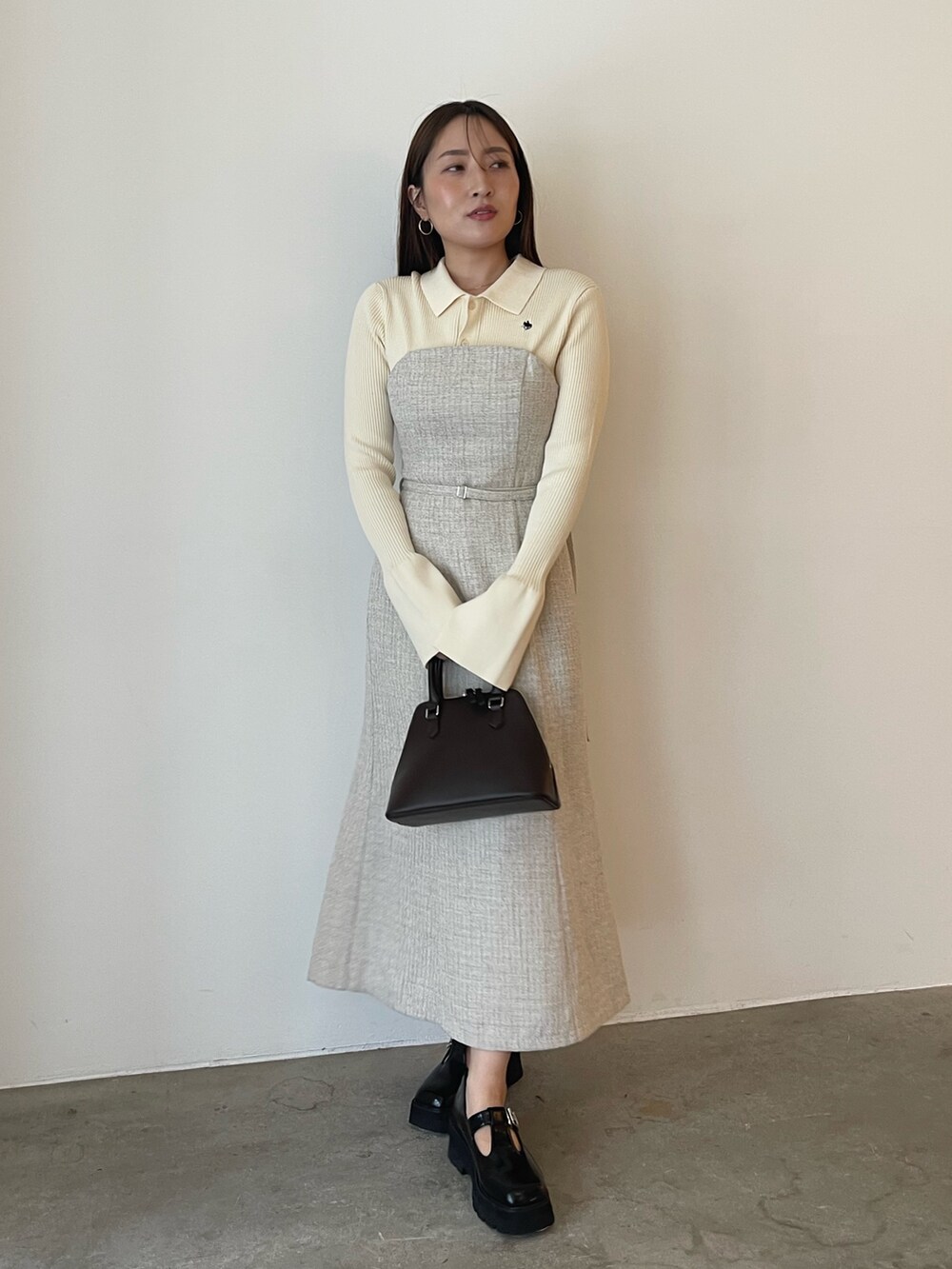 ブラウン系のボストンバッグ、ホワイト系のワンピース、ブラック系のローファーを着用したレディースの夏コーディネートの4枚目の写真