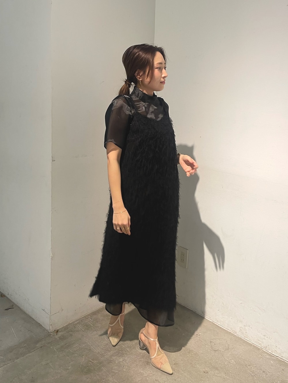 ベージュ系のパンプス、ブラック系のドレスを着用したレディースの春コーディネートの3枚目の写真