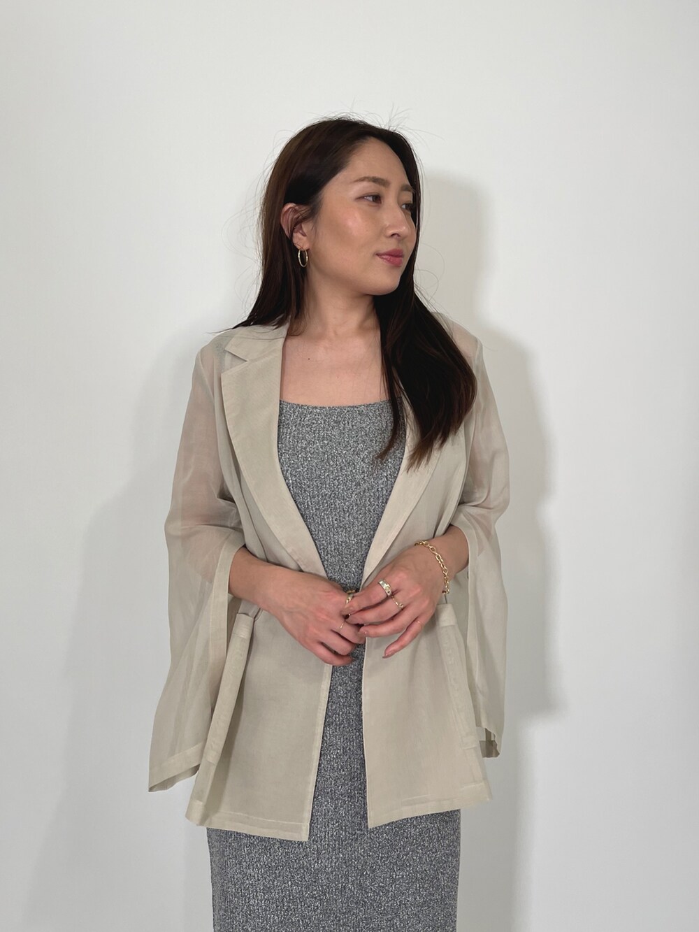 ホワイト系のテーラードジャケット、グレー系のワンピース、ブラック系のサンダルを着用したレディースの夏コーディネートの8枚目の写真