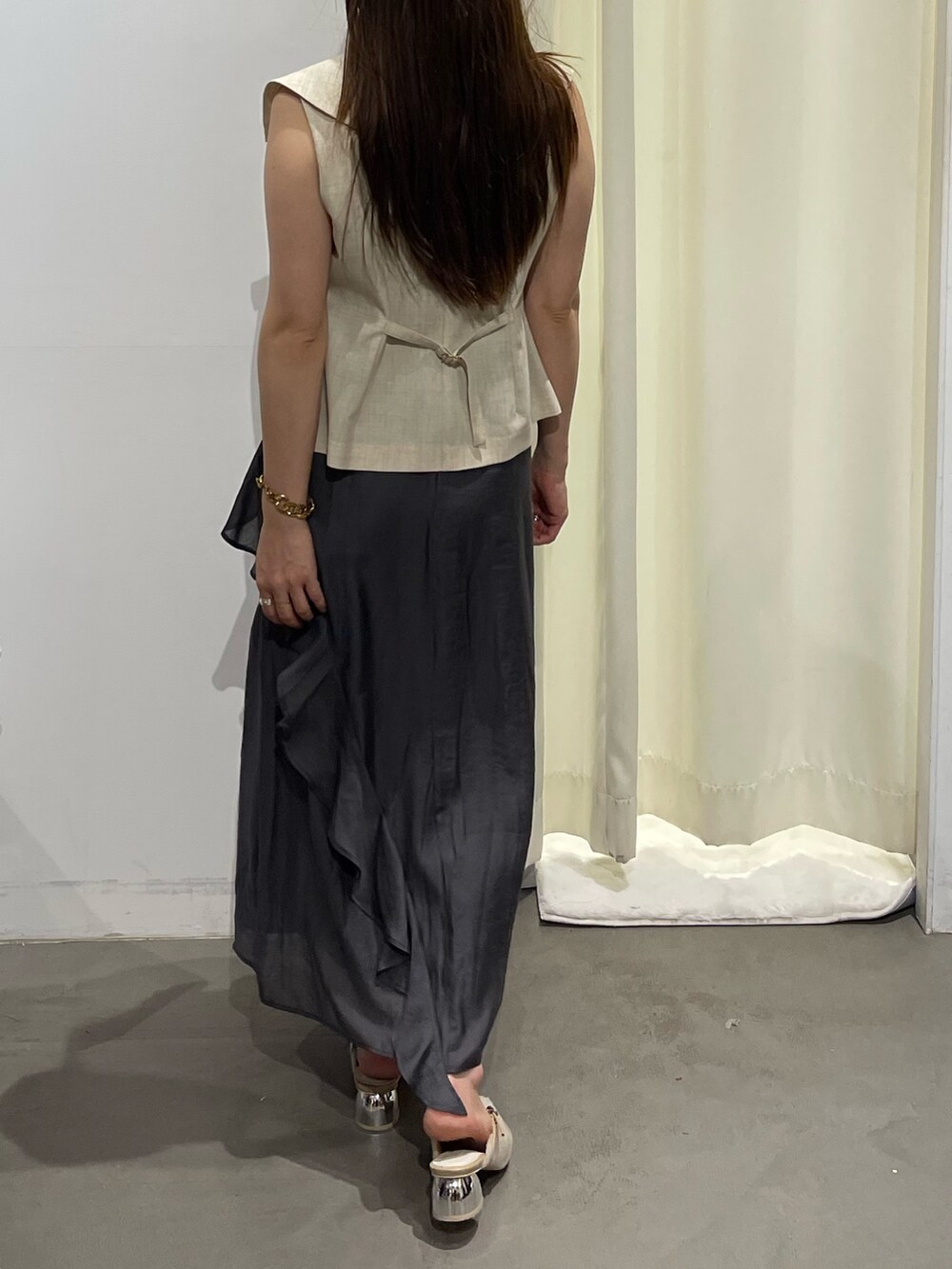 ホワイト系のベスト、グレー系のワンピース、ベージュ系のパンプスを着用したレディースの夏コーディネートの8枚目の写真